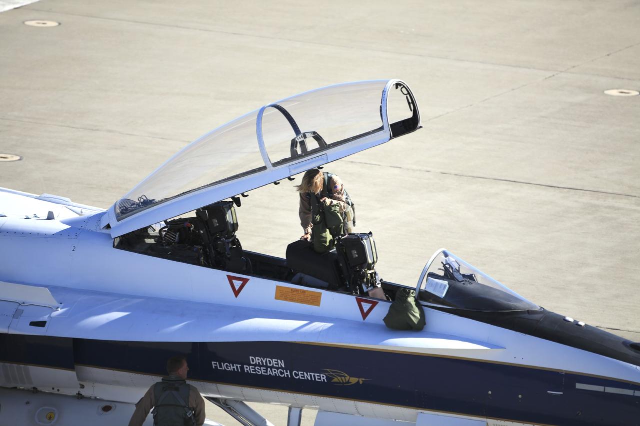 VANDENBERG AIR FORCE BASE, Calif. – Videographer Lori Losey boards an F-18 aircraft at Vandenberg Air Force Base in California. The F-18 "chase plane" will accompany the Orbital Sciences L-1011 aircraft as it transports the Pegasus XL rocket carrying NASA's Interface Region Imaging Spectrograph, or IRIS, solar observatory over the Pacific Ocean. Release of the rocket from under the wing of the L-1011 is scheduled for 10:27 p.m. EDT. IRIS will open a new window of discovery using spectrometry and imaging to trace the flow of energy and plasma through the chromospheres and transition region into the sun’s corona. The spacecraft will observe how solar material moves, gathers energy and heats up as it travels through a largely unexplored region of the solar atmosphere. This interface region, located between the sun's visible surface and its upper atmosphere, is where most of its ultraviolet emission is generated. These emissions impact the near-Earth space environment and Earth's climate. NASA's Launch Services Program at the agency's Kennedy Space Center in Florida is managing the countdown and launch. For more information, visit http://www.nasa.gov/iris. Photo credit: NASA/Daniel Casper