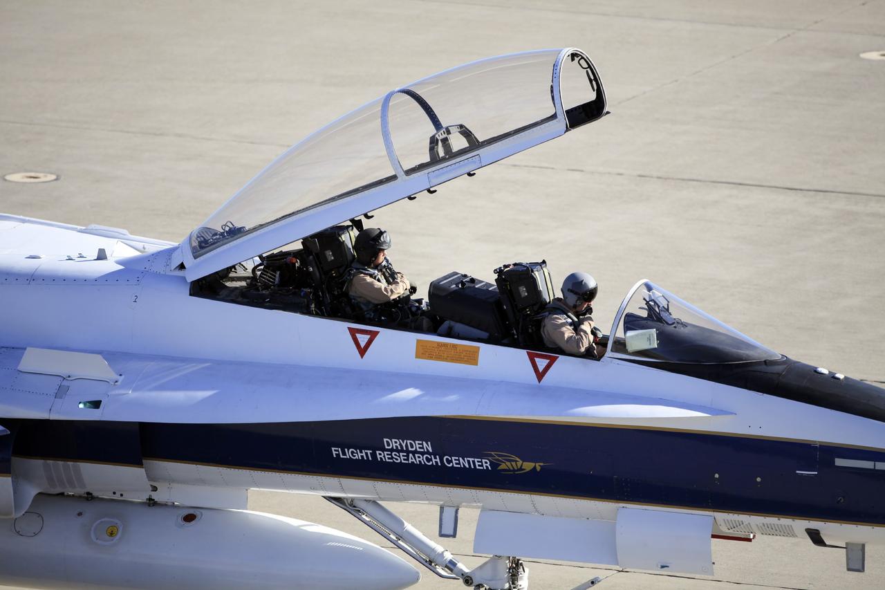 VANDENBERG AIR FORCE BASE, Calif. – Videographer Lori Losey, back seat, and pilot Jim Less board an F-18 aircraft at Vandenberg Air Force Base in California. The F-18 will be the "chase plane" for the Orbital Sciences L-1011 aircraft transporting the Pegasus XL rocket that will launch NASA's Interface Region Imaging Spectrograph, or IRIS, solar observatory to orbit. Release of the rocket from under the wing of the L-1011 is scheduled for 10:27 p.m. EDT. IRIS will open a new window of discovery using spectrometry and imaging to trace the flow of energy and plasma through the chromospheres and transition region into the sun’s corona. The spacecraft will observe how solar material moves, gathers energy and heats up as it travels through a largely unexplored region of the solar atmosphere. This interface region, located between the sun's visible surface and its upper atmosphere, is where most of its ultraviolet emission is generated. These emissions impact the near-Earth space environment and Earth's climate. NASA's Launch Services Program at the agency's Kennedy Space Center in Florida is managing the countdown and launch. For more information, visit http://www.nasa.gov/iris. Photo credit: NASA/Daniel Casper