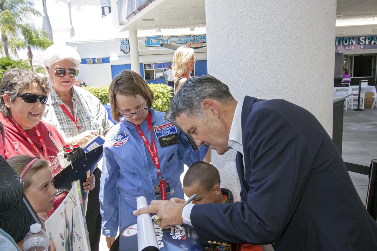 CAPE CANAVERAL, Fla. -- At the Kennedy Space Center Visitor Complex in Florida, center director Bob Cabana signs autographs for guests prior to the opening of the 90,000-square-foot "Space Shuttle Atlantis" facility.      The new $100 million facility includes interactive exhibits that tell the story of the 30-year Space Shuttle Program and highlight the future of space exploration. The "Space Shuttle Atlantis" exhibit formally opened to the public on June 29, 2013.Photo credit: NASA/Jim Grossmann