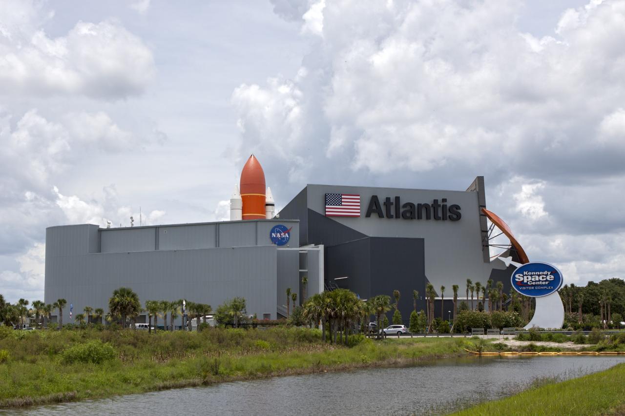 CAPE CANAVERAL, Fla. -- At the Kennedy Space Center Visitor Complex in Florida, the 90,000-square-foot "Space Shuttle Atlantis" facility has formally opened. On the opposite side of the building, a full-scale set of space shuttle twin solid rocket boosters and external fuel tank can be seen. Standing at the entrance to the exhibit building, guests may walk beneath the 184-foot-tall boosters and tank as they enter the facility. The facility features interactive exhibits that tell the story of the 30-year Space Shuttle Program and highlights the future of space exploration.      The new $100 million facility includes interactive exhibits that tell the story of the 30-year Space Shuttle Program and highlight the future of space exploration. The "Space Shuttle Atlantis" exhibit formally opened to the public on June 29, 2013.Photo credit: NASA/Jim Grossmann