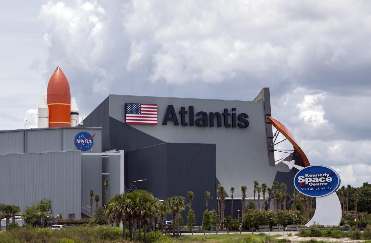 CAPE CANAVERAL, Fla. -- At the Kennedy Space Center Visitor Complex in Florida, the 90,000-square-foot "Space Shuttle Atlantis" facility has formally opened. On the opposite side of the building, a full-scale set of space shuttle twin solid rocket boosters and external fuel tank can be seen. Standing at the entrance to the exhibit building, guests may walk beneath the 184-foot-tall boosters and tank as they enter the facility. The facility features interactive exhibits that tell the story of the 30-year Space Shuttle Program and highlights the future of space exploration.      The new $100 million facility includes interactive exhibits that tell the story of the 30-year Space Shuttle Program and highlight the future of space exploration. The "Space Shuttle Atlantis" exhibit formally opened to the public on June 29, 2013.Photo credit: NASA/Jim Grossmann