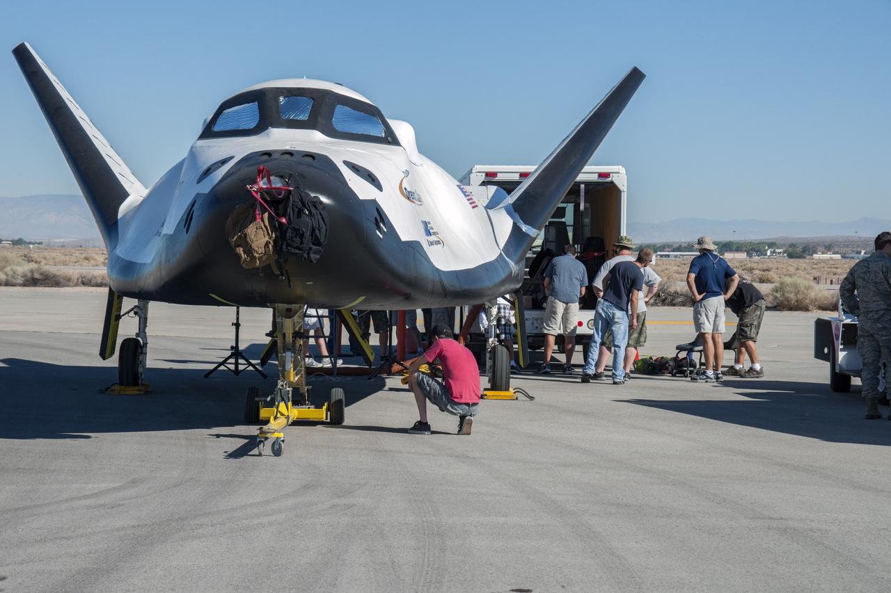 Edwards, Calif. – ED13-0215-024 - Sierra Nevada Corporation SNC Space Systems' team members prepare to tow the Dream Chaser flight vehicle along a concrete runway at NASA's Dryden Flight Research Center in California for range and taxi tow tests. The ground testing will validate the performance of the spacecraft's nose skid, brakes, tires and other systems prior to captive-carry and free-flight tests scheduled for later this year.    SNC is one of three companies working with NASA's Commercial Crew Program, or CCP, during the agency's Commercial Crew Integrated Capability, or CCiCap, initiative, which is intended to lead to the availability of commercial human spaceflight services for government and commercial customers. To learn more about CCP and its industry partners, visit www.nasa.gov/commercialcrew. Image credit: NASA/Ken Ulbrich