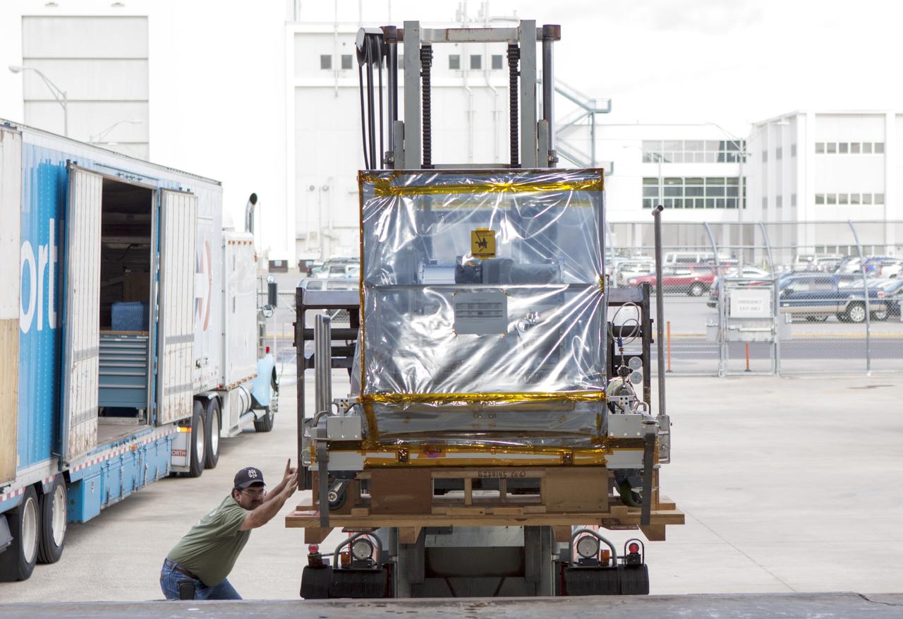 CAPE CANAVERAL, Fla. -- At NASA’s Kennedy Space Center in Florida, a technician monitors the progress as a forklift is used to move the Optical Payload for Lasercomm Science, or OPALS, experiment to the air lock entrance at the Space Station Processing Facility. The optical technology demonstration experiment arrived from the agency’s Jet Propulsion Laboratory in Pasadena, Calif.     NASA will use the International Space Station to test OPALS’ communications technology that could dramatically improve spacecraft communications, enhance commercial missions and strengthen transmission of scientific data. The experiment is slated to fly later this year aboard a SpaceX Dragon commercial resupply mission to the space station. The mission is expected to run 90 days after installation on the outside of the station. For more information about OPALS, visit: http://go.nasa.gov/10MMPDO. Photo credit: NASA/Jim Grossmann