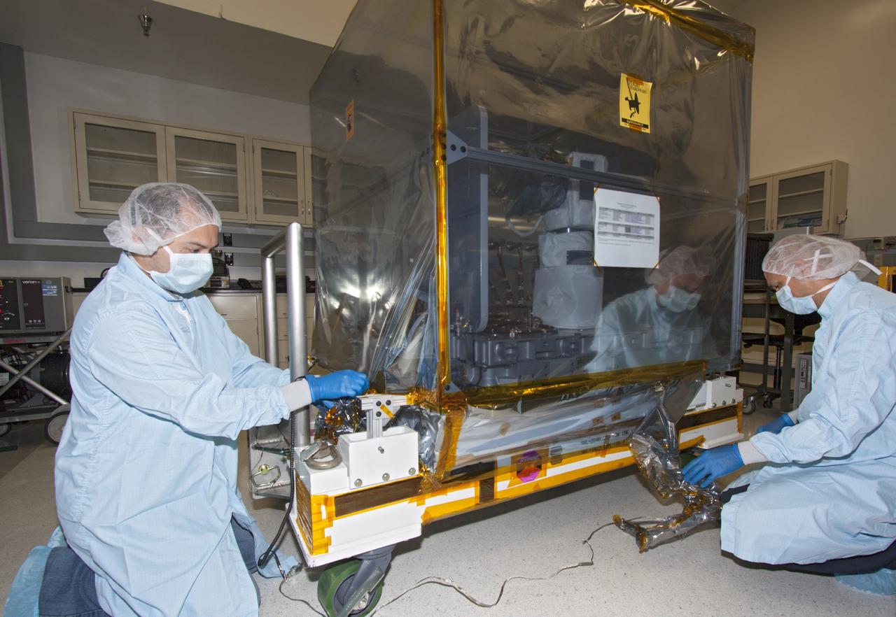 CAPE CANAVERAL, Fla. -- At NASA’s Kennedy Space Center in Florida, technicians prepare to uncover and check the Optical Payload for Lasercomm Science, or OPALS, experiment in a test cell at a Space Station Processing Facility offline laboratory. The optical technology demonstration experiment arrived from the agency’s Jet Propulsion Laboratory in Pasadena, Calif. NASA will use the International Space Station to test OPALS’ communications technology that could dramatically improve spacecraft communications, enhance commercial missions and strengthen transmission of scientific data. The experiment is slated to fly later this year aboard a SpaceX Dragon commercial resupply mission to the space station. The mission is expected to run 90 days after installation on the outside of the station. For more information about OPALS, visit: http://go.nasa.gov/10MMPDO. Photo credit: NASA/Jim Grossmann