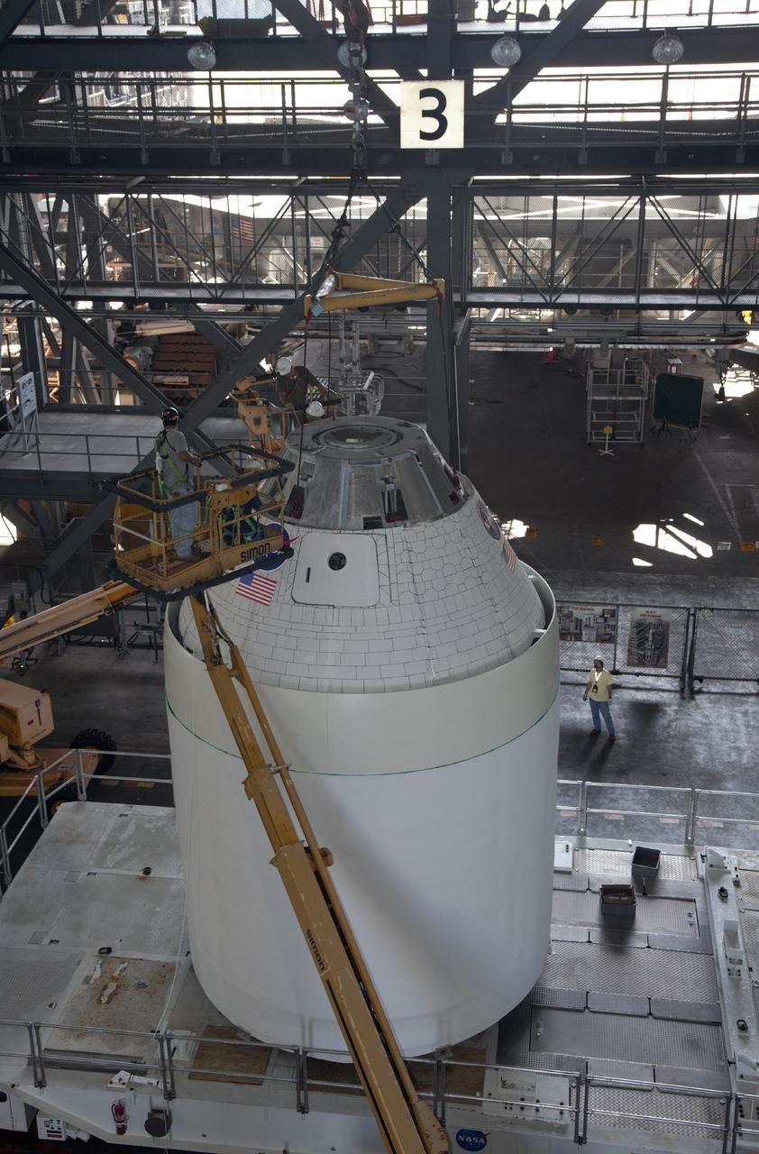 CAPE CANAVERAL, Fla. --In the transfer aisle of the Vehicle Assembly Building at NASA’s Kennedy Space Center in Florida, technicians attach a crane to a full-size mock-up of the Orion spacecraft to prepare it to be lifted into High Bay 4. Crane operators and technicians practice stacking and de-stacking operations in order to keep processing procedures and skills current for the Ground Systems Development and Operations Program. Orion is the exploration spacecraft designed to carry crews to space beyond low Earth orbit. It will provide emergency abort capability, sustain the crew during the space travel and provide safe re-entry from deep space return velocities. Orion’s first unpiloted test flight is scheduled to launch in 2014 atop a Delta IV rocket. A second uncrewed flight test is scheduled for 2017 on NASA’s Space Launch System rocket. For more information, visit http://www.nasa.gov/orion. Photo credit: NASA/Dan Casper
