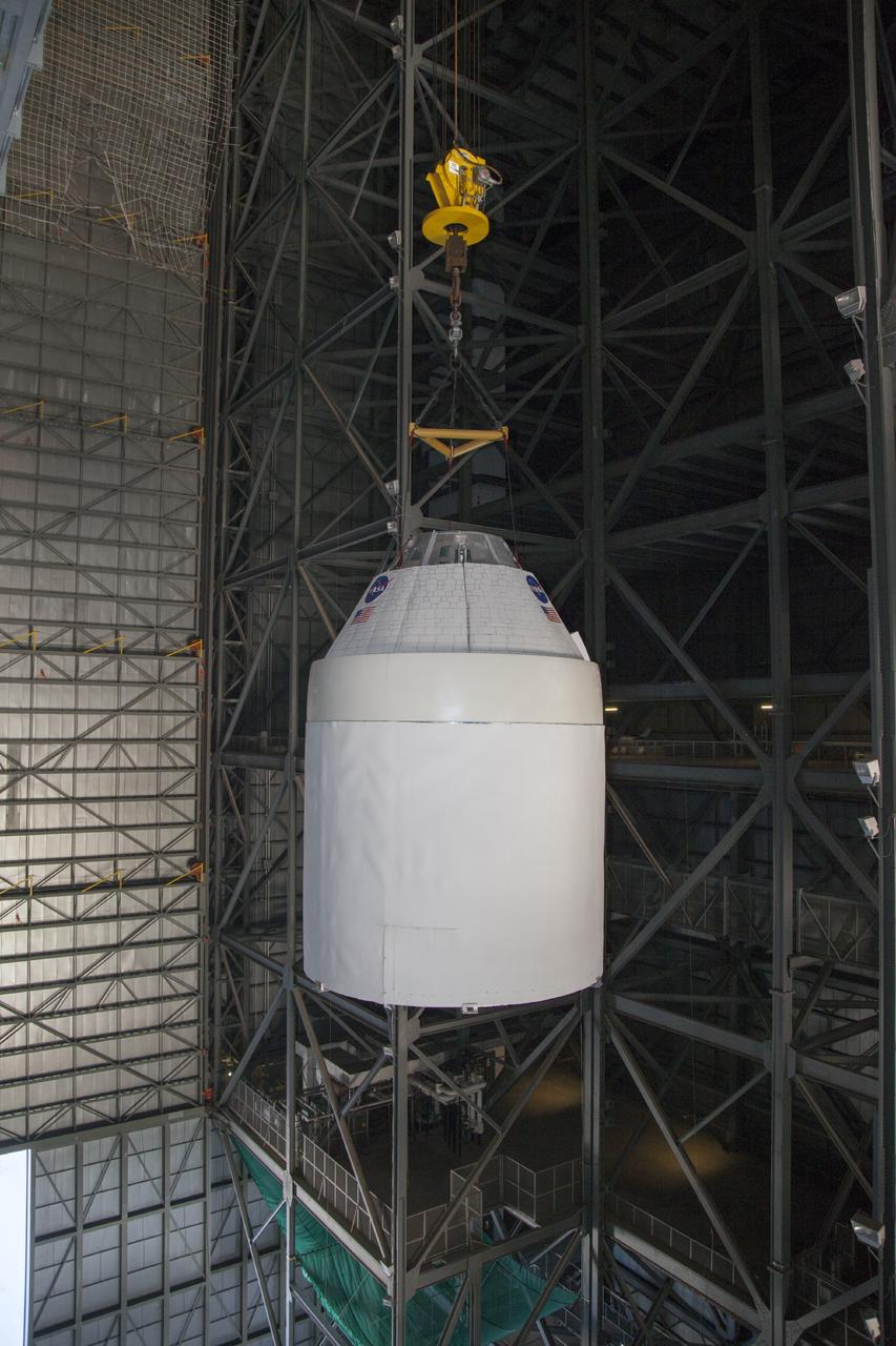 CAPE CANAVERAL, Fla. -- In the transfer aisle of the Vehicle Assembly Building at NASA’s Kennedy Space Center in Florida, a crane operator lifts a full-size mock-up of the Orion spacecraft high in the air for transfer to High Bay 4. Crane operators and technicians practice stacking and de-stacking operations in order to keep processing procedures and skills current for the Ground Systems Development and Operations Program. Orion is the exploration spacecraft designed to carry crews to space beyond low Earth orbit. It will provide emergency abort capability, sustain the crew during the space travel and provide safe re-entry from deep space return velocities. Orion’s first unpiloted test flight is scheduled to launch in 2014 atop a Delta IV rocket. A second uncrewed flight test is scheduled for 2017 on NASA’s Space Launch System rocket. For more information, visit http://www.nasa.gov/orion. Photo credit: NASA/Dan Casper