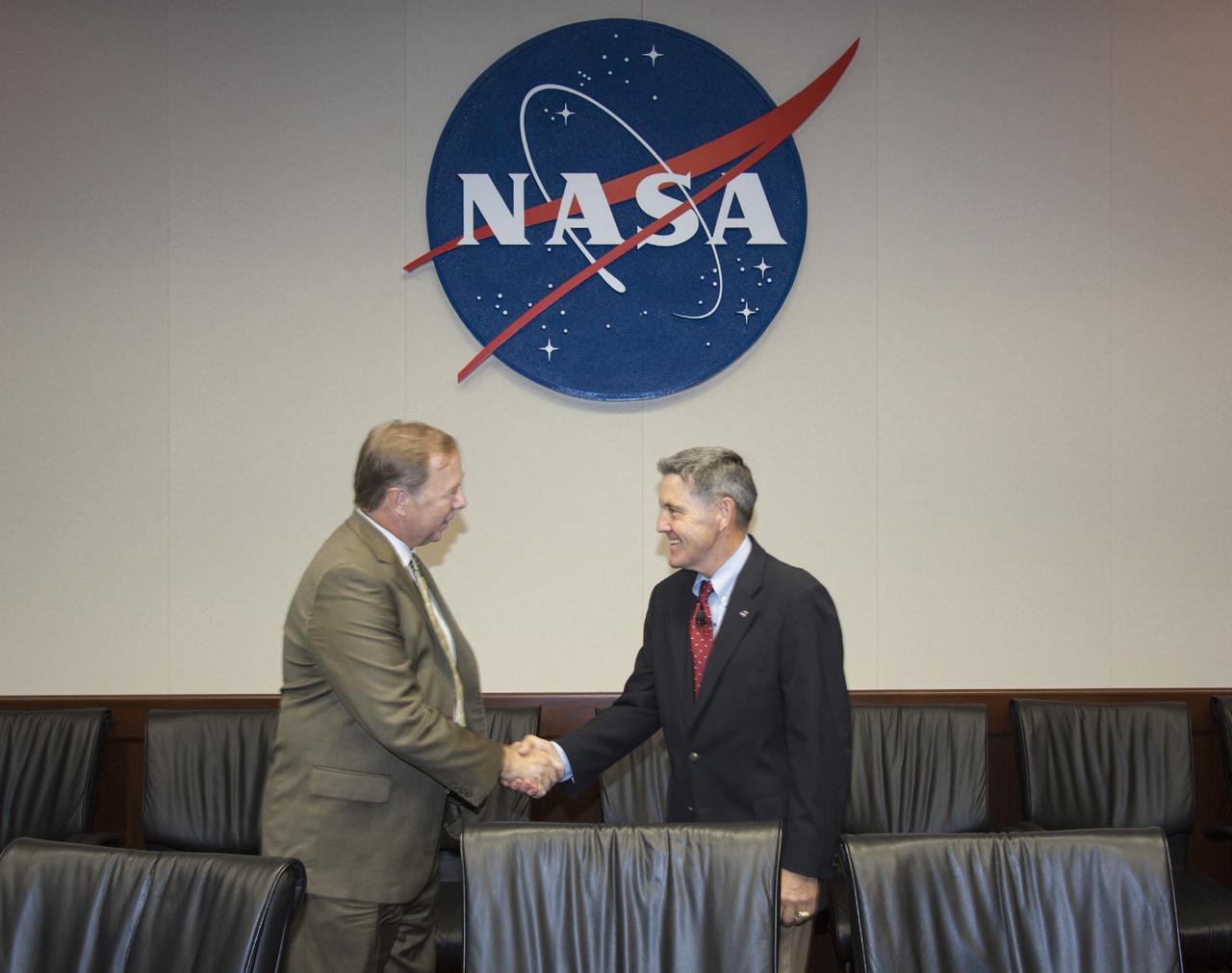 CAPE CANAVERAL, Fla. – At NASA’s Kennedy Space Center in Florida, Director Bob Cabana, at right, shakes hands with Larry Williams, president and CEO of Ballistic Recovery Systems Inc., or BRS Aerospace of Miami, Fla., after signing a new partnership agreement for use of the Parachute Refurbishment Facility, or PRF. Under a 10-year lease agreement, BRS Aerospace will operate and maintain the facility. The PRF previously was used during NASA’s Space Shuttle Program to manufacture and refurbish the solid rocket booster parachutes. Because of NASA’s transition from the shuttle to future commercial and government mission activities, the agreement allows NASA to preserve the unique facility capabilities for future spaceflight projects. Kennedy’s Center Planning and Development team and the Economic Development Commission of Florida’s Space Coast worked with BRS Aerospace to establish the agreement. For more information about BRS Aerospace, visit http://www.brsparachutes.com. Photo credit: NASA/Jim Grossmann