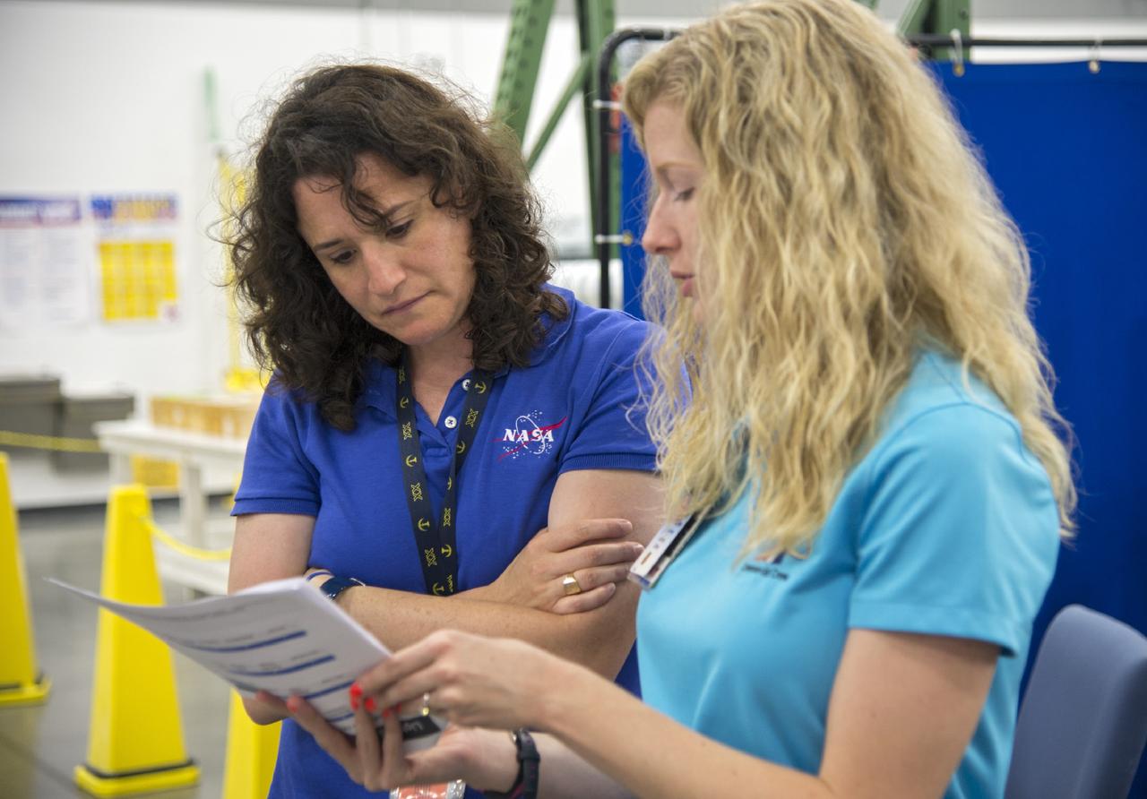 HOUSTON - NASA astronaut Serena Aunon and Andrea Gilkey, a human factors engineer with The Boeing Company, tag up before Aunon puts on her orange launch-and-entry suit for a fit check evaluation of the CST-100 spacecraft at the company's Houston Product Support Center. Aunon's fit check will help evaluate a crew's maneuverability in the spacecraft and test communications. Boeing's CST-100 is being designed to transport crew members or a mix of crew and cargo to low-Earth-orbit destinations, including the International Space Station. The evaluation is part of the ongoing work supporting Boeing's funded Space Act Agreement with NASA's Commercial Crew Program, or CCP, during the agency's Commercial Crew Integrated Capability, or CCiCap, initiative. CCiCap is intended to make commercial human spaceflight services available for government and commercial customers.      To learn more about CCP, visit http://www.nasa.gov/commercialcrew. Photo credit: NASA/Robert Markowitz