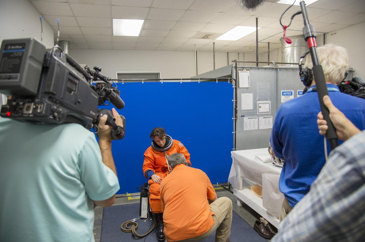 HOUSTON - NASA astronaut Serena Aunon puts on her orange launch-and-entry suit for a fit check evaluation of The Boeing Company's CST-100 spacecraft at the company's Houston Product Support Center. Aunon's fit check will help evaluate a crew's maneuverability in the spacecraft and test communications. Boeing's CST-100 is being designed to transport crew members or a mix of crew and cargo to low-Earth-orbit destinations. The evaluation is part of the ongoing work supporting Boeing's funded Space Act Agreement with NASA's Commercial Crew Program, or CCP, during the agency's Commercial Crew Integrated Capability, or CCiCap, initiative. CCiCap is intended to make commercial human spaceflight services available for government and commercial customers.  To learn more about CCP, visit http://www.nasa.gov/commercialcrew. Photo credit: NASA/Robert Markowitz