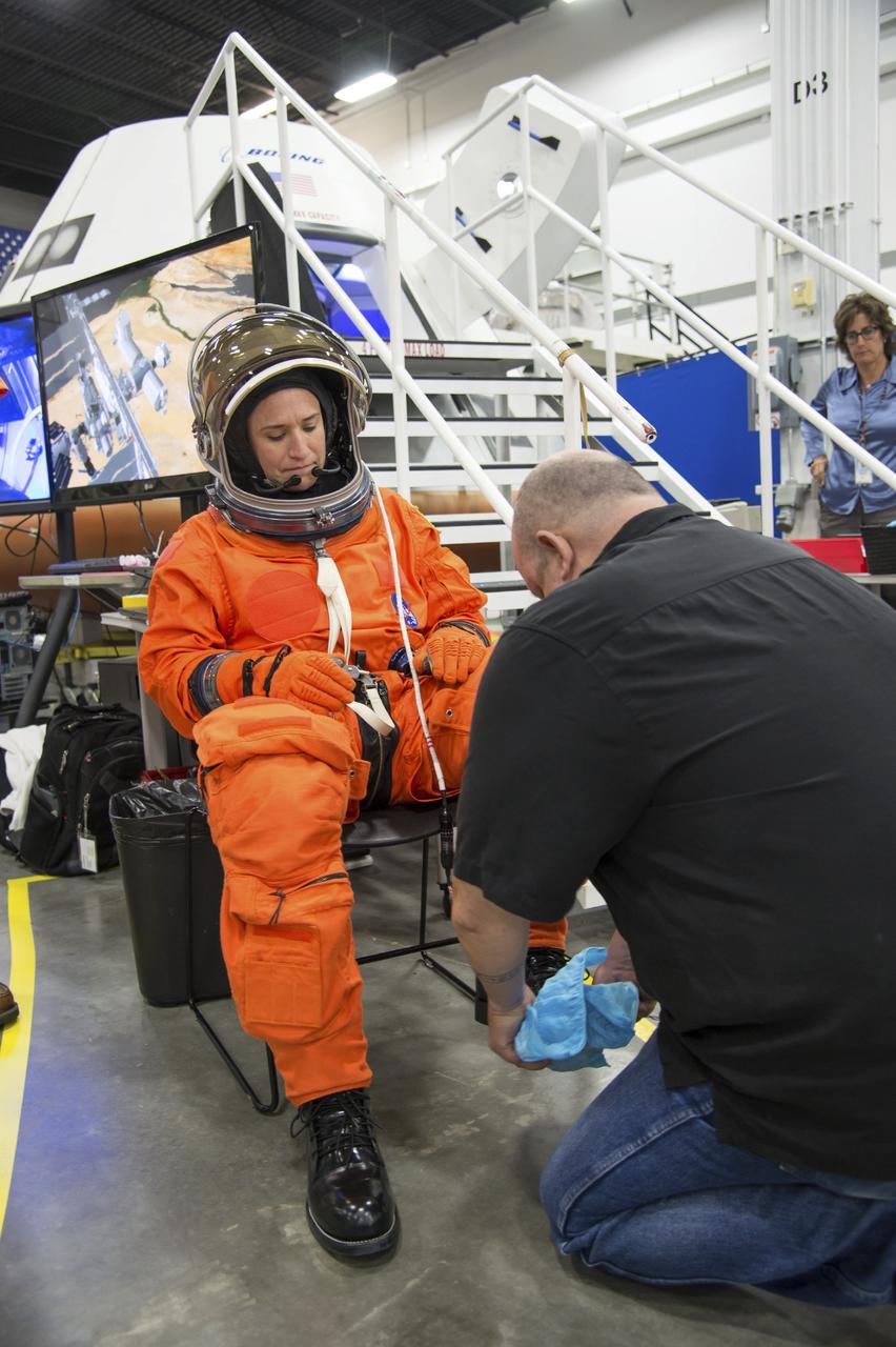 HOUSTON - JSC2013e068264 - NASA astronaut Serena Aunon's boots are covered before she enters The Boeing Company's CST-100 spacecraft for a fit check evaluation at the company's Houston Product Support Center. Aunon's fit check will help evaluate a crew's maneuverability in the spacecraft and test communications.      Boeing's CST-100 is being designed to transport crew members or a mix of crew and cargo to low-Earth-orbit destinations. The evaluation is part of the ongoing work supporting Boeing's funded Space Act Agreement with NASA's Commercial Crew Program, or CCP, during the agency's Commercial Crew Integrated Capability, or CCiCap, initiative. CCiCap is intended to make commercial human spaceflight services available for government and commercial customers. To learn more about CCP, visit http://www.nasa.gov/commercialcrew. Photo credit: NASA/Robert Markowitz
