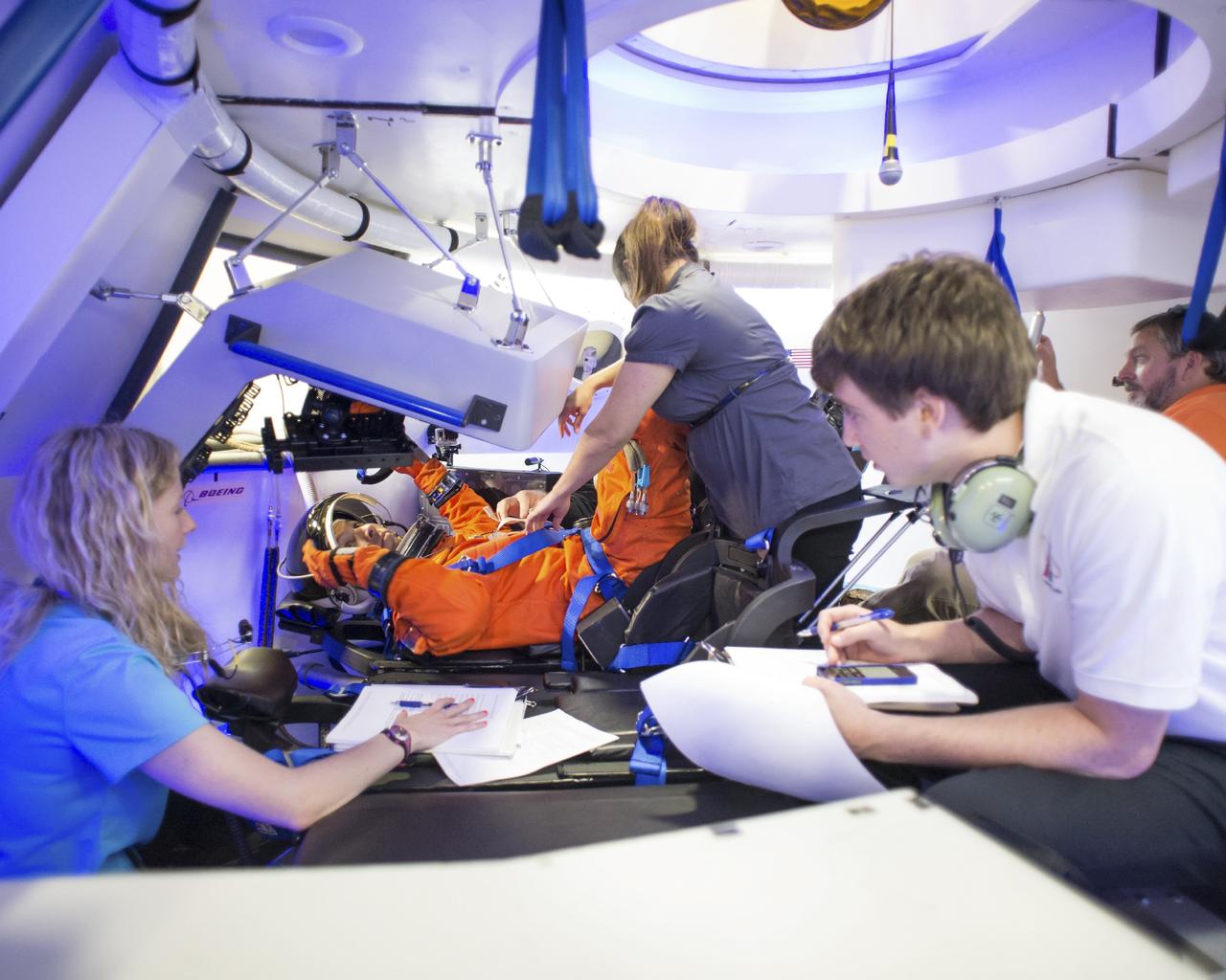 HOUSTON - JSC2013e068344 - NASA astronaut Randy Bresnik gets into position in The Boeing Company's CST-100 spacecraft for a fit check evaluation at the company's Houston Product Support Center. Bresnik's fit check will help evaluate a crew's maneuverability in the spacecraft and test communications.     Boeing's CST-100 is being designed to transport crew members or a mix of crew and cargo to low-Earth-orbit destinations. The evaluation is part of the ongoing work supporting Boeing's funded Space Act Agreement with NASA's Commercial Crew Program, or CCP, during the agency's Commercial Crew Integrated Capability, or CCiCap, initiative. CCiCap is intended to make commercial human spaceflight services available for government and commercial customers. To learn more about CCP, visit http://www.nasa.gov/commercialcrew. Photo credit: NASA/Robert Markowitz