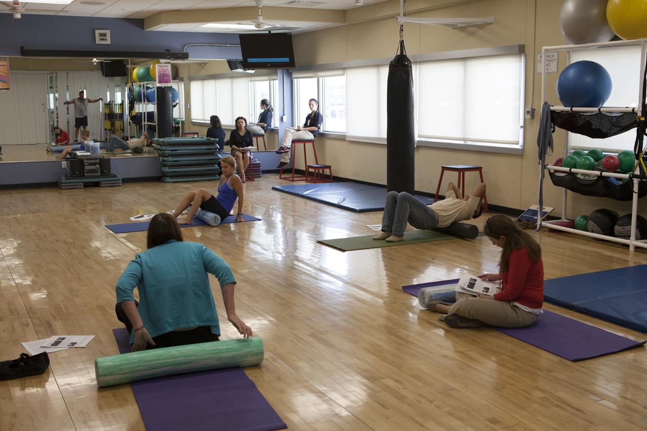 CAPE CANAVERAL, Fla. – Kennedy Space Center workers learn about the benefits of foam-rolling exercises and techniques to relieve the strain and pain of overused muscles and connective tissue. The class was part of the National Employee Health and Fitness Day event. Yoga, cardio dance, and boot camp classes were also offered throughout the day at the Operations and Checkout Building's Fitness Center. Photo credit: NASA/ Dimitri Gerondidakis