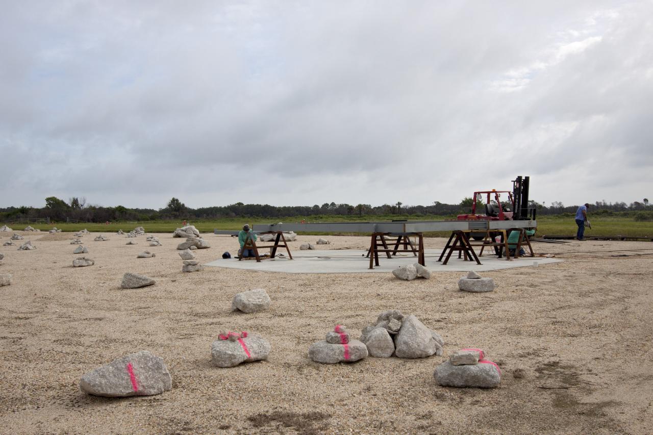 CAPE CANAVERAL, Fla. – At NASA’s Kennedy Space Center in Florida, technicians work on the buildup of a movable launch platform for the Project Morpheus lander at the midfield of the Shuttle Landing Facility, or SLF.    Testing of the prototype lander has been ongoing at NASA’s Johnson Space Center in Houston in preparation for free flight. The SLF will provide the lander with the kind of field necessary for realistic testing, complete with rocks, craters and hazards to avoid. Morpheus utilizes an autonomous landing and hazard avoidance technology, or ALHAT, payload that will allow it to navigate to clear landing sites amidst rocks, craters and other hazards during its descent. Project Morpheus is one of 20 small projects comprising the Advanced Exploration Systems, or AES, program in NASA’s Human Exploration and Operations Mission Directorate. AES projects pioneer new approaches for rapidly developing prototype systems, demonstrating key capabilities and validating operational concepts for future human missions beyond Earth orbit. For more information on Project Morpheus, visit http://www.nasa.gov/centers/johnson/exploration/morpheus/index.html.  Photo credit: NASA/Jim Grossmann