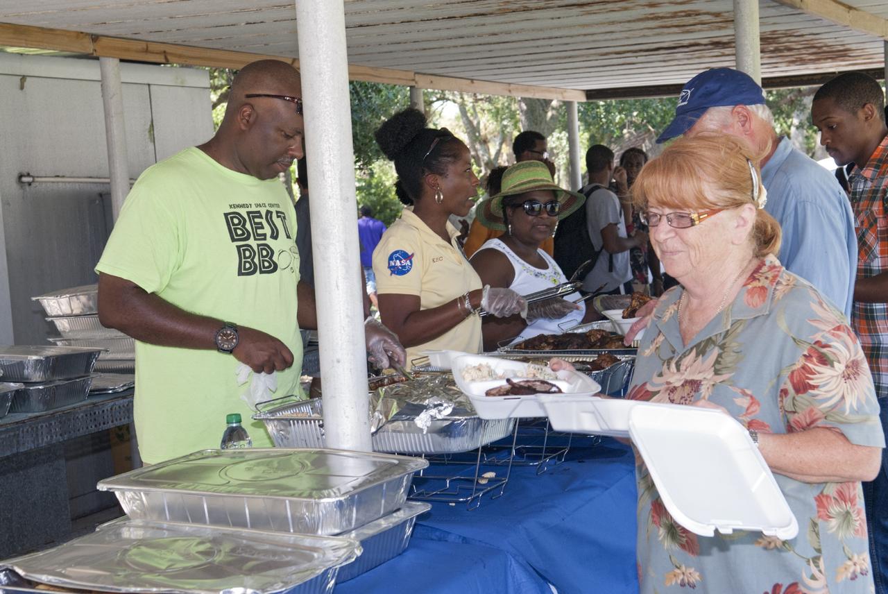 Merritt Island, Fla. – Kennedy Space Center worker James Davis, Maxine Daniels, and Bettye Lee serve delicious food to attendees  at the 2013 Black Employee Strategy Team BEST  BBQ at KARS I Park on Merritt Island. Events included a noncompetitive car show and a spades tournament. BEST hosts the barbecue as a fundraiser for the Evelyn Johnson Scholarship, which is handed out every year to students who exemplify significant achievement both academically and in their community. The scholarship is in honor of Evelyn Johnson, a founding member of BEST and former deputy director of Kennedy’s Diversity and Equal Opportunity Office. Photo credit: NASA/ Charisse Nahser