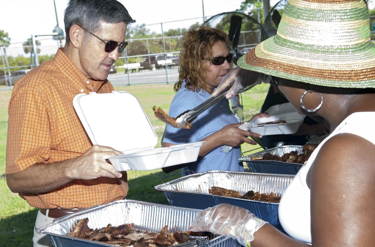 Merritt Island, Fla. – Kennedy Space Center worker Bettye Lee serves Center Director Bob Cabana some delicious food at the 2013 The Black Employee Strategy Team BEST  BBQ at KARS I Park on Merritt Island. Events included a noncompetitive car show and a spades tournament. BEST hosts the barbecue as a fundraiser for the Evelyn Johnson Scholarship, which is handed out every year to students who exemplify significant achievement both academically and in their community. The scholarship is in honor of Evelyn Johnson, a founding member of BEST and former deputy director of Kennedy’s Diversity and Equal Opportunity office. Photo credit: NASA/ Charisse Nahser