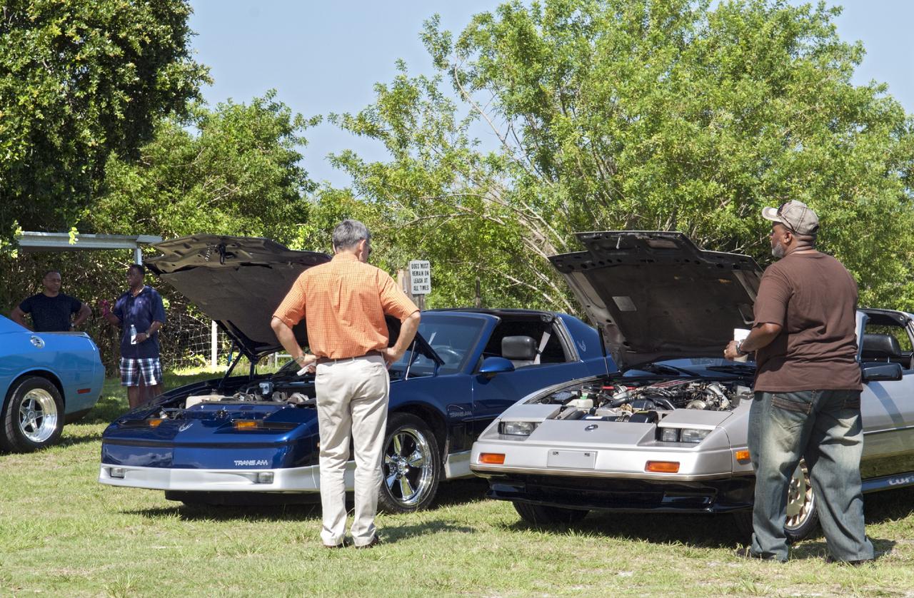 Merritt Island, Fla. – Kennedy Space Center Director Bob Cabana enjoys the automobiles on display in the a noncompetitive car show at 2013 Black Employee Strategy Team BEST  BBQ at KARS Park I on Merritt Island. Events also included a spades tournament. BEST hosts the barbecue as a fundraiser for the Evelyn Johnson Scholarship, which is handed out every year to students who exemplify significant achievement both academically and in their community. The scholarship is in honor of Evelyn Johnson, a founding member of BEST and former deputy director of Kennedy’s Diversity and Equal Opportunity Office. Photo credit: NASA/ Charisse Nahser