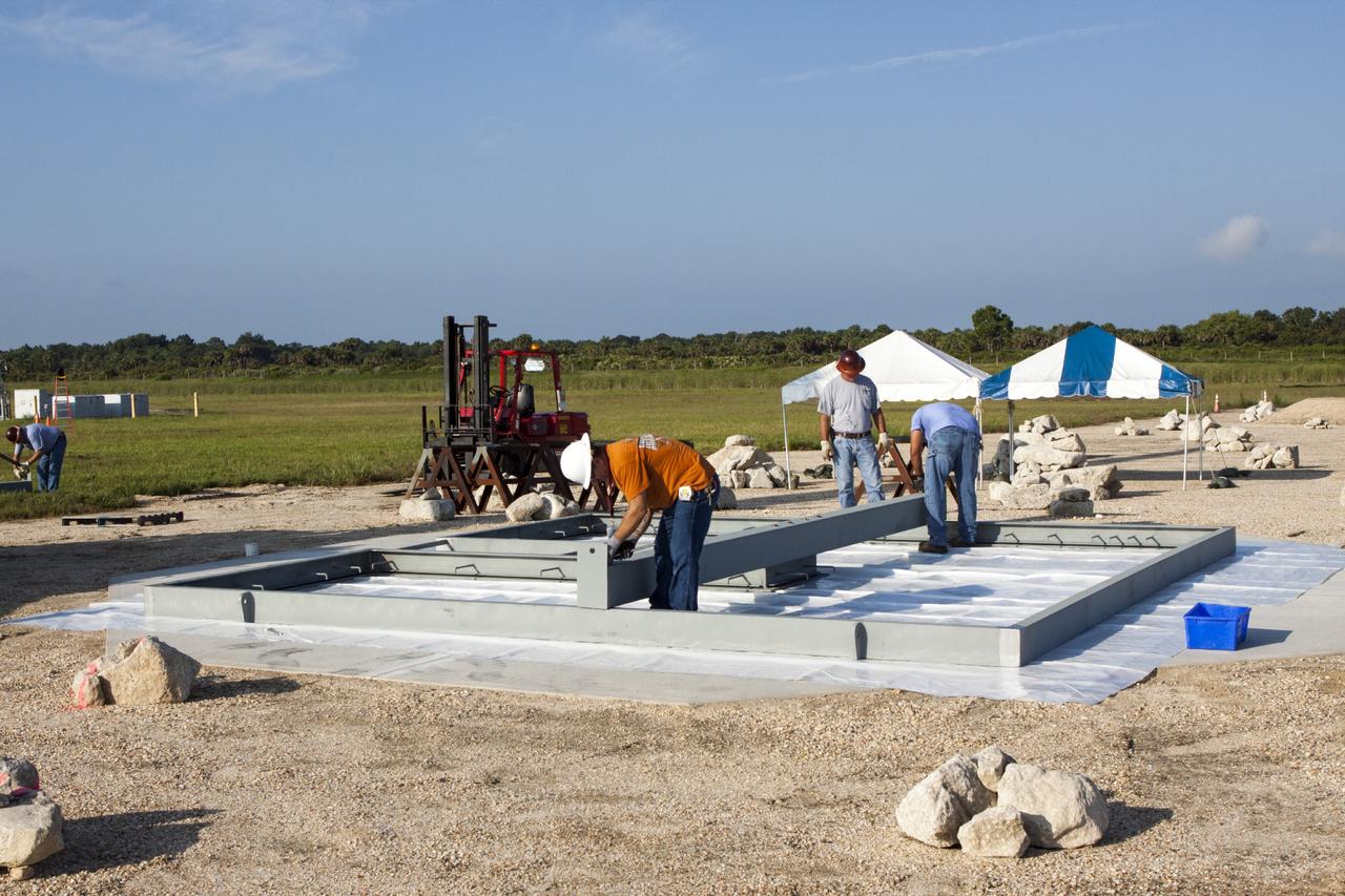 CAPE CANAVERAL, Fla. – At NASA’s Kennedy Space Center in Florida, technicians work on the buildup of a movable launch platform for the Project Morpheus lander at the Shuttle Landing Facility, or SLF.    Testing of the prototype lander has been ongoing at NASA’s Johnson Space Center in Houston in preparation for free flight. The SLF will provide the lander with the kind of field necessary for realistic testing, complete with rocks, craters and hazards to avoid. Morpheus utilizes an autonomous landing and hazard avoidance technology, or ALHAT, payload that will allow it to navigate to clear landing sites amidst rocks, craters and other hazards during its descent. Project Morpheus is one of 20 small projects comprising the Advanced Exploration Systems, or AES, program in NASA’s Human Exploration and Operations Mission Directorate. AES projects pioneer new approaches for rapidly developing prototype systems, demonstrating key capabilities and validating operational concepts for future human missions beyond Earth orbit. For more information on Project Morpheus, visit http://www.nasa.gov/centers/johnson/exploration/morpheus/index.html.  Photo credit: NASA/Jim Grossmann