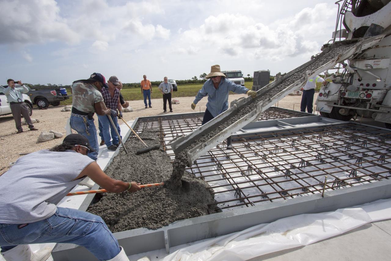 CAPE CANAVERAL, Fla. –At NASA’s Kennedy Space Center in Florida, technicians pour concrete onto the movable launch platform for the Project Morpheus lander at the north end of the Shuttle Landing Facility, or SLF.    Testing of the prototype lander has been ongoing at NASA’s Johnson Space Center in Houston in preparation for free flight. The SLF will provide the lander with the kind of field necessary for realistic testing, complete with rocks, craters and hazards to avoid. Morpheus utilizes an autonomous landing and hazard avoidance technology, or ALHAT, payload that will allow it to navigate to clear landing sites amidst rocks, craters and other hazards during its descent. Project Morpheus is one of 20 small projects comprising the Advanced Exploration Systems, or AES, program in NASA’s Human Exploration and Operations Mission Directorate. AES projects pioneer new approaches for rapidly developing prototype systems, demonstrating key capabilities and validating operational concepts for future human missions beyond Earth orbit. For more information on Project Morpheus, visit http://www.nasa.gov/centers/johnson/exploration/morpheus/index.html. Photo credit: NASA/Jim Grossmann