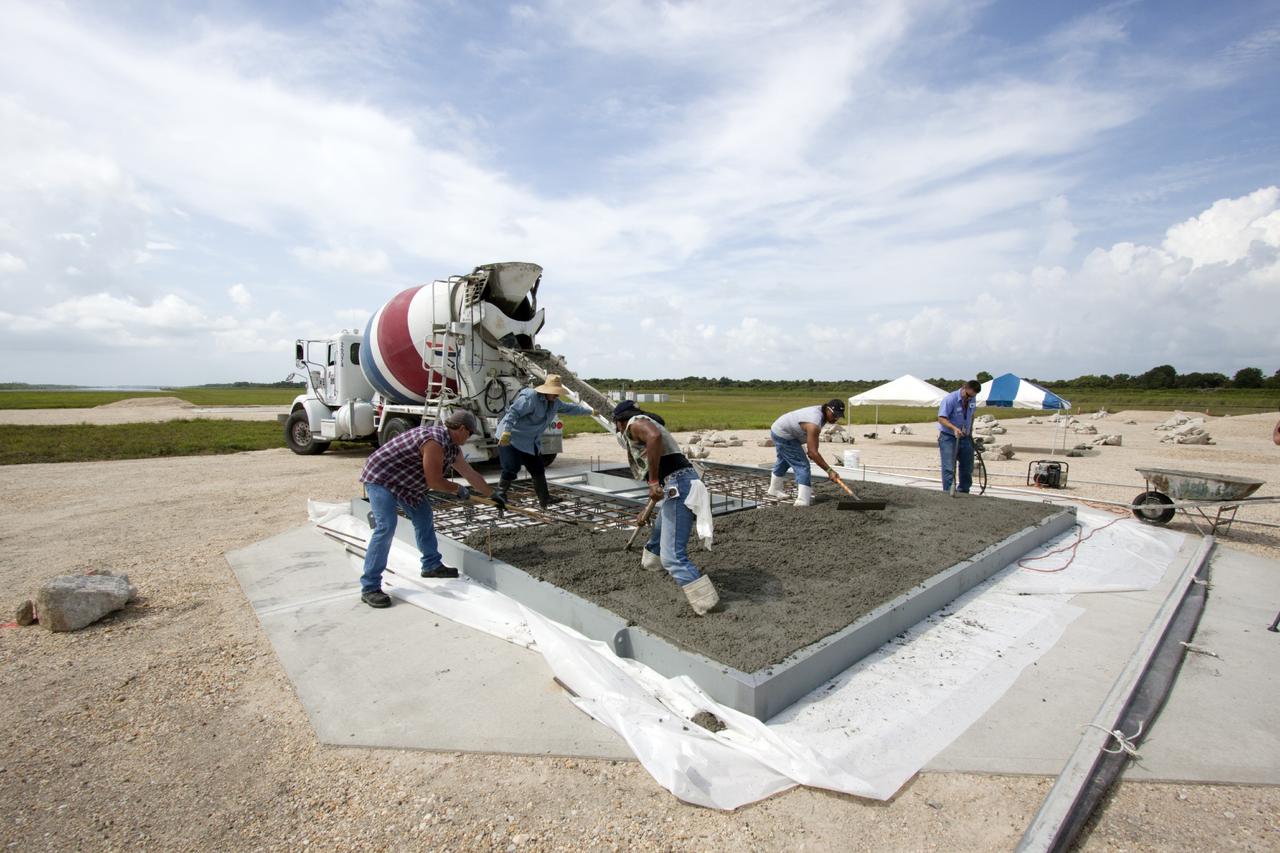 CAPE CANAVERAL, Fla. – At NASA’s Kennedy Space Center in Florida, technicians pour concrete onto the movable launch platform for the Project Morpheus lander at the north end of the Shuttle Landing Facility, or SLF. Testing of the prototype lander has been ongoing at NASA’s Johnson Space Center in Houston in preparation for free flight. The SLF will provide the lander with the kind of field necessary for realistic testing, complete with rocks, craters and hazards to avoid. Morpheus utilizes an autonomous landing and hazard avoidance technology, or ALHAT, payload that will allow it to navigate to clear landing sites amidst rocks, craters and other hazards during its descent. Project Morpheus is one of 20 small projects comprising the Advanced Exploration Systems, or AES, program in NASA’s Human Exploration and Operations Mission Directorate. AES projects pioneer new approaches for rapidly developing prototype systems, demonstrating key capabilities and validating operational concepts for future human missions beyond Earth orbit. For more information on Project Morpheus, visit http://www.nasa.gov/centers/johnson/exploration/morpheus/index.html. Photo credit: NASA/Jim Grossmann