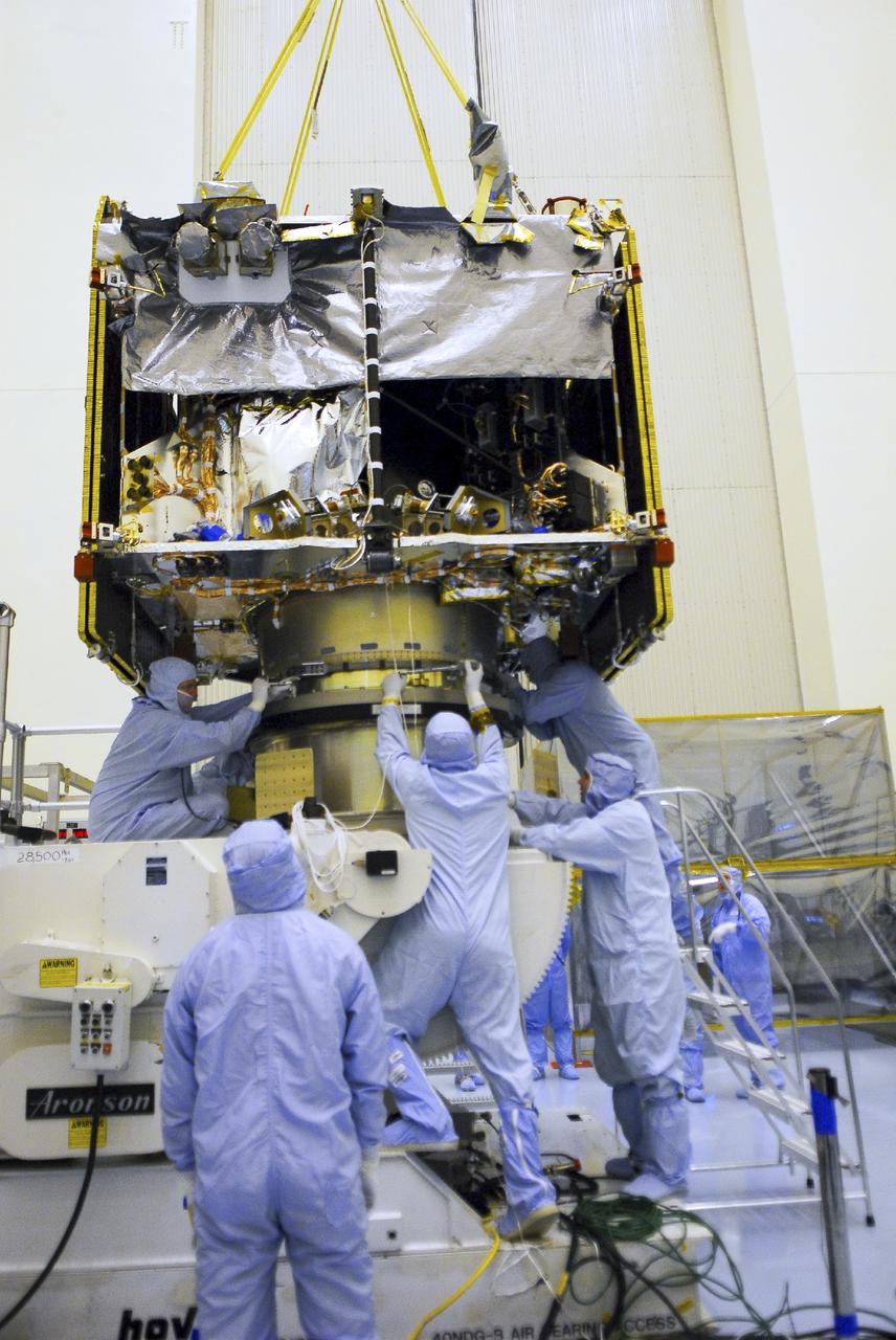CAPE CANAVERAL, Fla. – Engineers fasten NASA’s Mars Atmosphere and Volatile Evolution MAVEN spacecraft to a processing stand inside the Payload Hazardous Servicing Facility on Aug. 3, 2013, at the agency’s Kennedy Space Center in Florida. MAVEN will be prepared inside the facility for its scheduled November launch to Mars. Positioned in an orbit above the Red Planet, MAVEN will study the upper atmosphere of Mars in unprecedented detail. Photo credit: NASA/Tim Jacobs