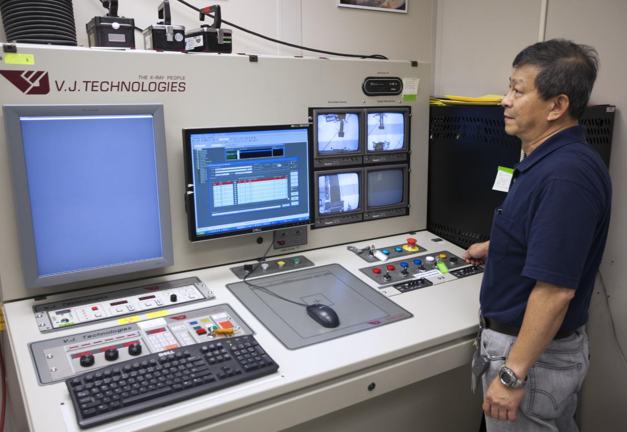 CAPE CANAVERAL, Fla. – In Hangar N at Cape Canaveral Air Force Station, PaR Systems, Inc. development engineer Wayne Cheng operates the controller for a robotic system used in nondestructive testing. The 11-axis robotic system takes X-ray images of hardware for evaluation.      NASA's Kennedy Space Center in Florida recently established a partnership agreement with PaR Systems, Inc. of Shoreview, Minn., for operation of the Hangar N facility and its nondestructive testing and evaluation equipment. As the spaceport transitions from a historically government-only launch facility to a multi-user spaceport for both federal and commercial customers, partnerships between the space agency and other organizations will be a key element in that effort. Hangar N is located at Cape Canaveral Air Force Station adjacent to Kennedy and houses a unique inventory of test and evaluation equipment and the capability for current and future mission spaceflight support. Photo credit: NASA/ Dimitri Gerondidakis