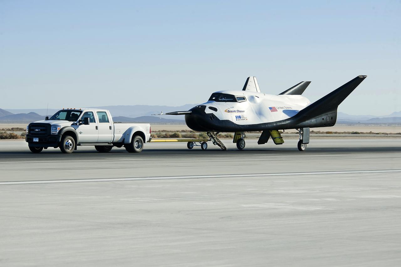 Edwards, Calif. – ED13-0266-047- A pickup truck pulls the Sierra Nevada Corporation, or SNC, Dream Chaser flight vehicle through 60 mile per hour tow tests on taxi and runways at NASA's Dryden Flight Research Center at Edwards Air Force Base in California. Ground testing at 10, 20, 40 and 60 miles per hour is helping the company validate the performance of the spacecraft's braking and landing systems prior to captive-carry and free-flight tests scheduled for later this year.            SNC is continuing the development of its Dream Chaser spacecraft under the agency's Commercial Crew Development Round 2, or CCDev2, and Commercial Crew Integrated Capability, or CCiCap, phases, which are intended to lead to the availability of commercial human spaceflight services for government and commercial customers. To learn more about CCP and its industry partners, visit www.nasa.gov/commercialcrew. Image credit: NASA/Ken Ulbrich