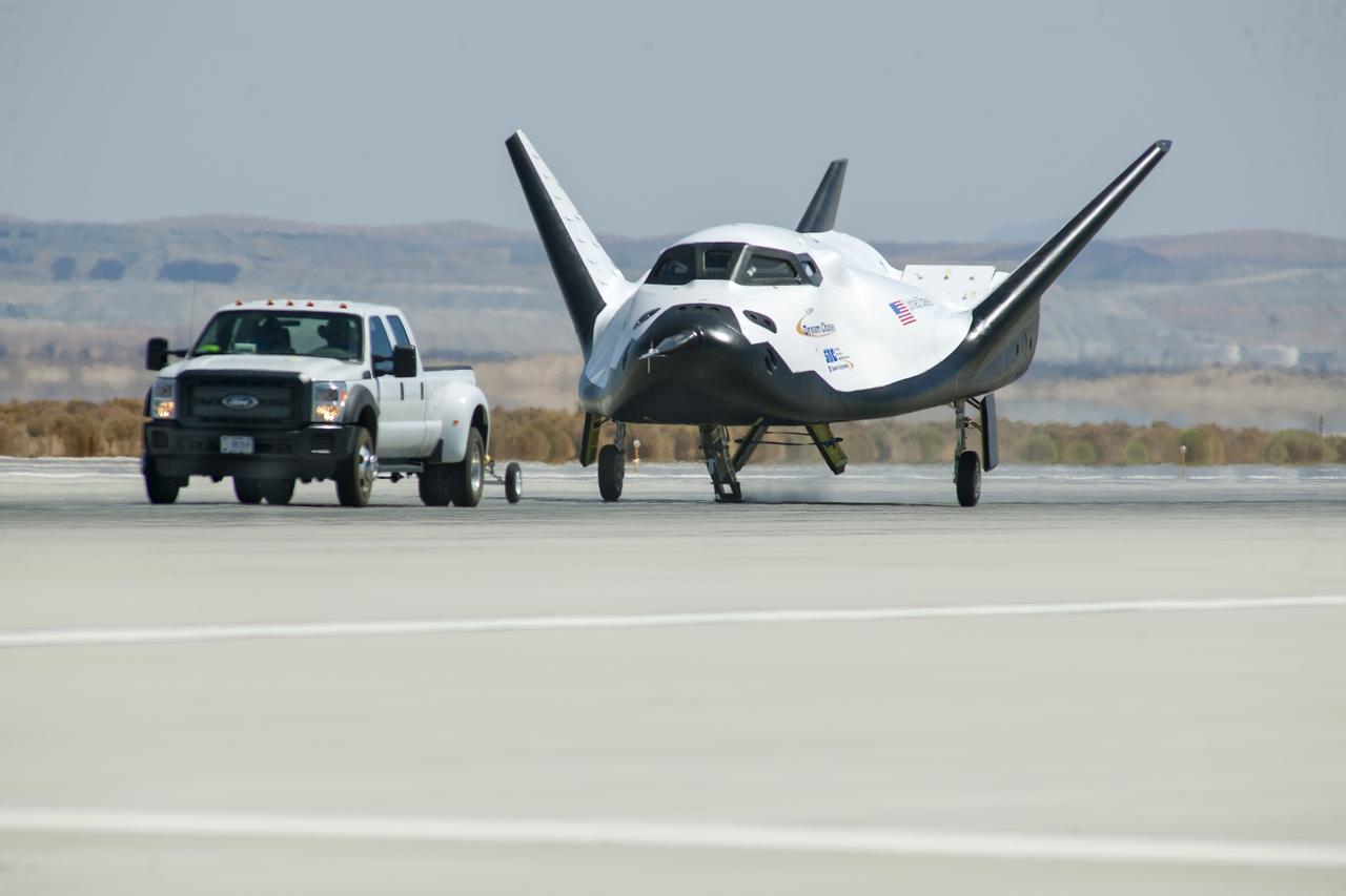 Edwards, Calif. – ED13-0266-047- A pickup truck pulls the Sierra Nevada Corporation, or SNC, Dream Chaser flight vehicle through 60 mile per hour tow tests on taxi and runways at NASA's Dryden Flight Research Center at Edwards Air Force Base in California. Ground testing at 10, 20, 40 and 60 miles per hour is helping the company validate the performance of the spacecraft's braking and landing systems prior to captive-carry and free-flight tests scheduled for later this year.              SNC is continuing the development of its Dream Chaser spacecraft under the agency's Commercial Crew Development Round 2, or CCDev2, and Commercial Crew Integrated Capability, or CCiCap, phases, which are intended to lead to the availability of commercial human spaceflight services for government and commercial customers. To learn more about CCP and its industry partners, visit www.nasa.gov/commercialcrew. Image credit: NASA/Ken Ulbrich