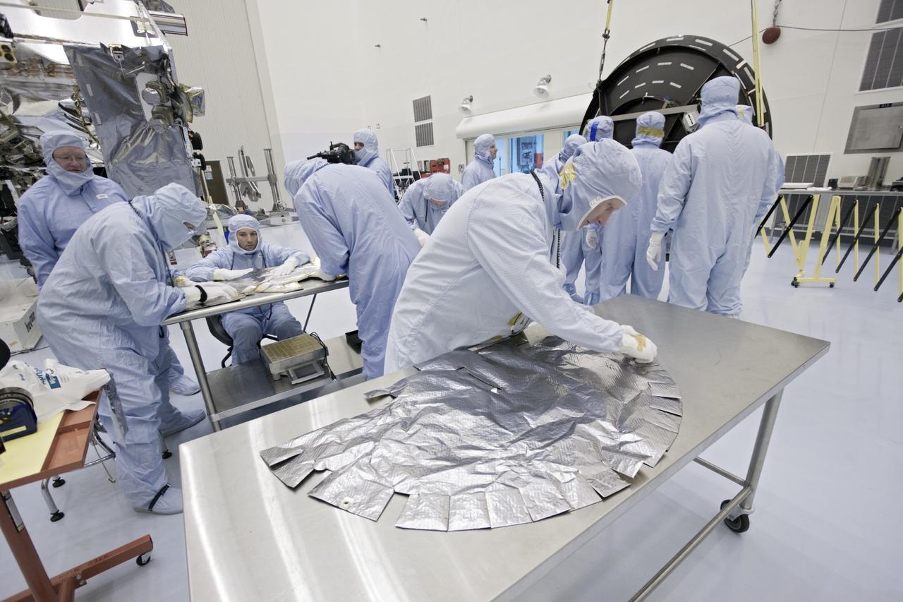 CAPE CANAVERAL, Fla. – Inside the Payload Hazardous Servicing Facility at NASA's Kennedy Space Center in Florida, technicians prepare a thermal blanket for installation on the MAVEN spacecraft's parabolic high gain antenna. MAVEN stands for Mars Atmosphere and Volatile Evolution.      The antenna will communicate vast amounts of data to Earth during the mission. MAVEN is being prepared inside the facility for its scheduled November launch aboard a United Launch Alliance Atlas V rocket to Mars. Positioned in an orbit above the Red Planet, MAVEN will study the upper atmosphere of Mars in unprecedented detail. Photo credit: NASA/Jim Grossmann
