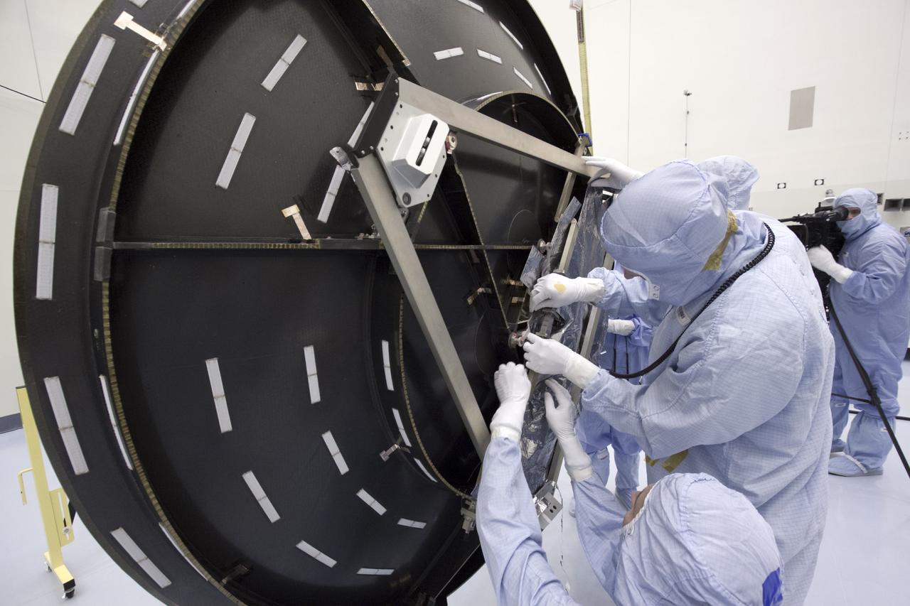 CAPE CANAVERAL, Fla. – Inside the Payload Hazardous Servicing Facility at NASA's Kennedy Space Center in Florida, technicians install a thermal blanket on the parabolic high gain antenna of the Mars Atmosphere and Volatile Evolution, or MAVEN spacecraft.      The antenna will communicate vast amounts of data to Earth during the mission. MAVEN is being prepared inside the facility for its scheduled November launch aboard a United Launch Alliance Atlas V rocket to Mars. Positioned in an orbit above the Red Planet, MAVEN will study the upper atmosphere of Mars in unprecedented detail. Photo credit: NASA/Jim Grossmann