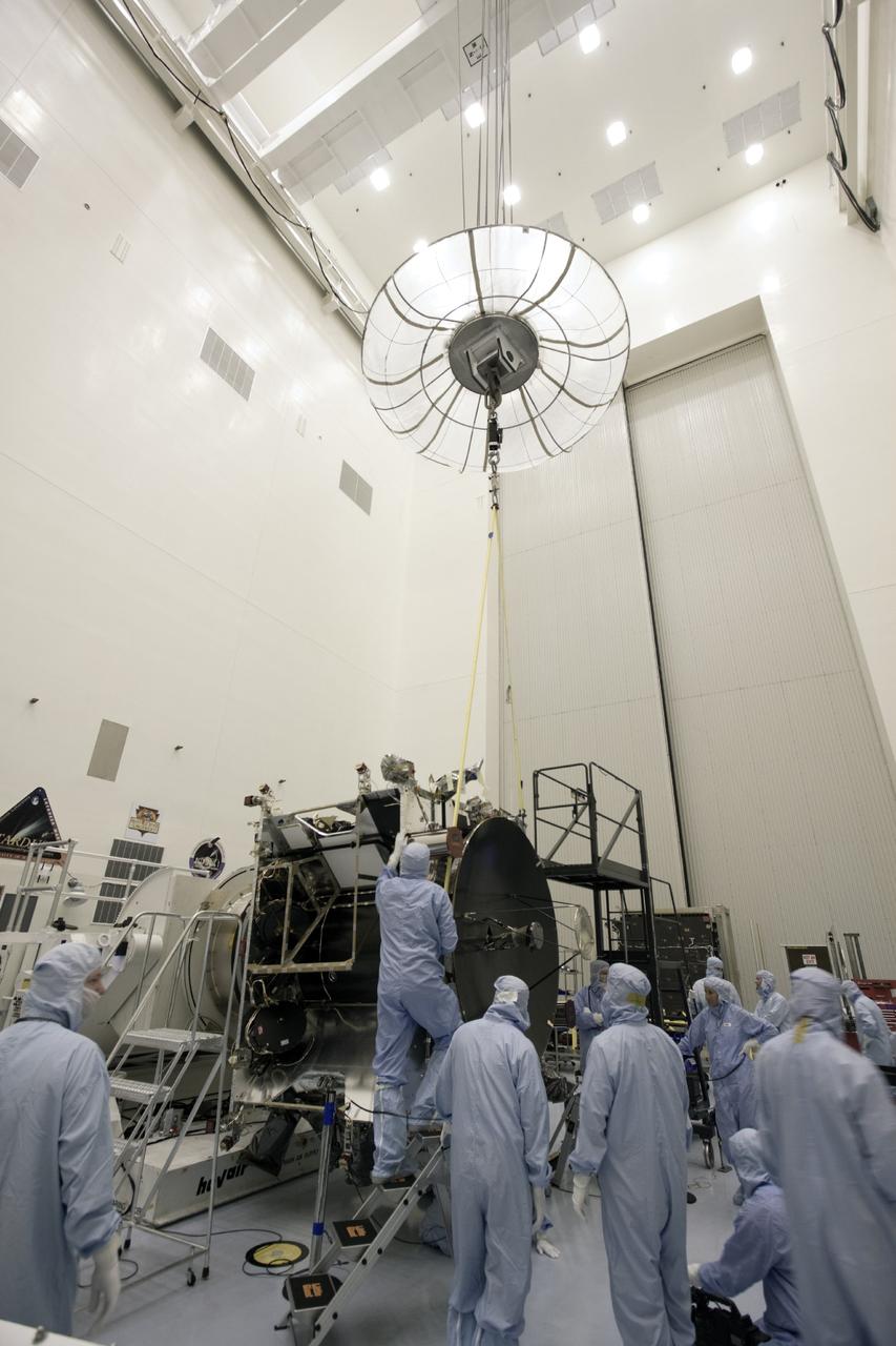 CAPE CANAVERAL, Fla. – Inside the Payload Hazardous Servicing Facility at NASA's Kennedy Space Center in Florida, technicians use an overhead crane to guide the parabolic high gain antenna into place prior to installation on the Mars Atmosphere and Volatile Evolution, or MAVEN spacecraft.      The antenna will communicate vast amounts of data to Earth during the mission. MAVEN is being prepared inside the facility for its scheduled November launch aboard a United Launch Alliance Atlas V rocket to Mars. Positioned in an orbit above the Red Planet, MAVEN will study the upper atmosphere of Mars in unprecedented detail. Photo credit: NASA/Jim Grossmann