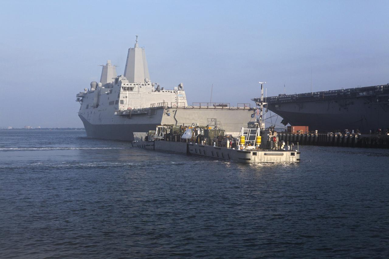 HAMPTON, Va. – At the Naval Station Norfolk near NASA’s Langley Research Center in Virginia, a floating dock system carries the Orion boilerplate test article and support equipment for a stationary recovery test aboard a U.S. Navy ship. NASA and the U.S. Navy are conducting tests to prepare for recovery of the Orion crew module and forward bay cover on its return from a deep space mission. The stationary recovery test will allow the teams to demonstrate and evaluate the recovery processes, procedures, hardware and personnel in a controlled environment before conducting a second recovery test next year in open waters. Orion is the exploration spacecraft designed to carry astronauts to destinations not yet explored by humans, including an asteroid and Mars. It will have emergency abort capability, sustain the crew during space travel and provide safe re-entry from deep space return velocities. The first unpiloted test flight of the Orion is scheduled to launch in 2014 atop a Delta IV rocket and in 2017 on a Space Launch System rocket. For more information, visit http://www.nasa.gov/orion. Photo credit: NASA/Dimitri Gerondidakis