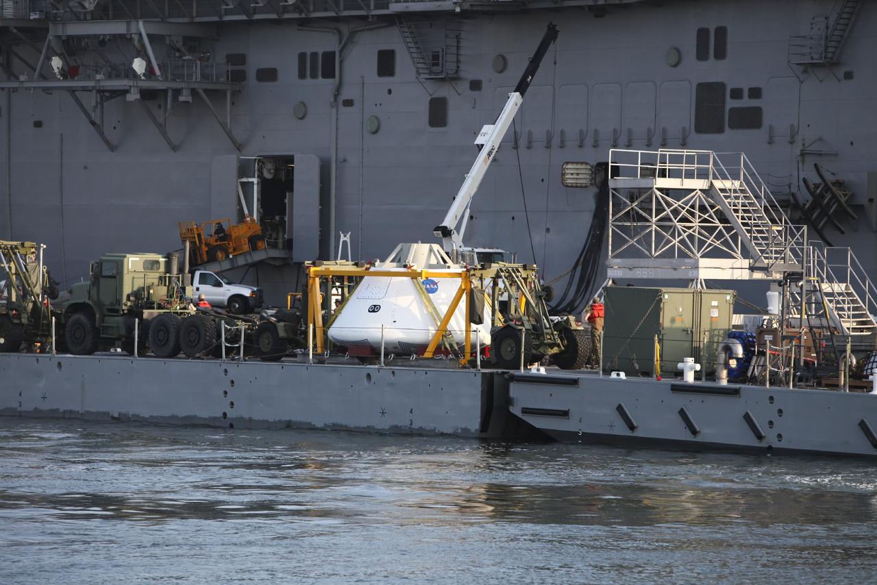 HAMPTON, Va. – At the Naval Station Norfolk near NASA’s Langley Research Center in Virginia, the Orion boilerplate test article and support equipment for a stationary recovery test are being transferred on a floating dock system to a U.S. Navy ship. NASA and the U.S. Navy are conducting tests to prepare for recovery of the Orion crew module and forward bay cover on its return from a deep space mission. The stationary recovery test will allow the teams to demonstrate and evaluate the recovery processes, procedures, hardware and personnel in a controlled environment before conducting a second recovery test next year in open waters. Orion is the exploration spacecraft designed to carry astronauts to destinations not yet explored by humans, including an asteroid and Mars. It will have emergency abort capability, sustain the crew during space travel and provide safe re-entry from deep space return velocities. The first unpiloted test flight of the Orion is scheduled to launch in 2014 atop a Delta IV rocket and in 2017 on a Space Launch System rocket. For more information, visit http://www.nasa.gov/orion. Photo credit: NASA/Dimitri Gerondidakis