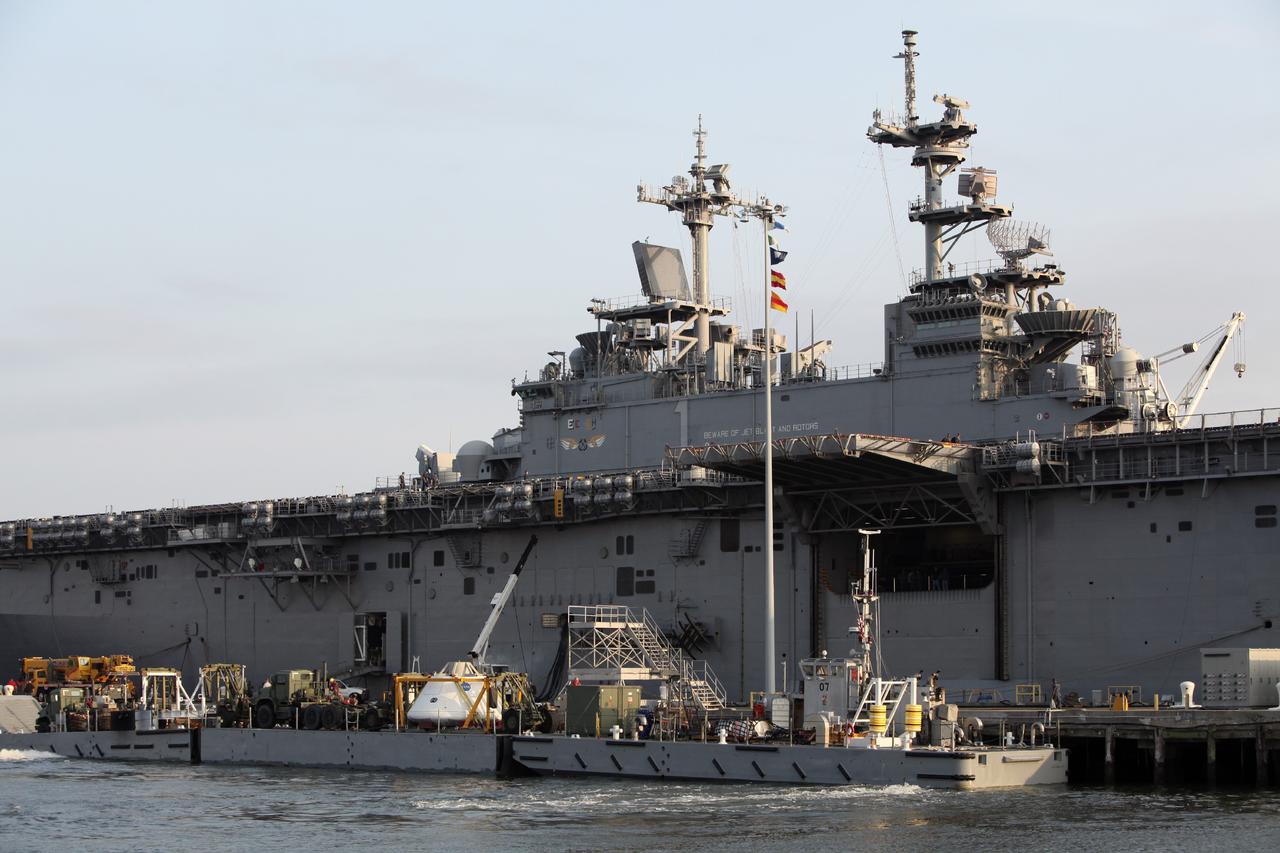 HAMPTON, Va. – At the Naval Station Norfolk near NASA’s Langley Research Center in Virginia, the Orion boilerplate test article and support equipment for a stationary recovery test are being transferred on a floating dock system to a U.S. Navy ship. NASA and the U.S. Navy are conducting tests to prepare for recovery of the Orion crew module and forward bay cover on its return from a deep space mission. The stationary recovery test will allow the teams to demonstrate and evaluate the recovery processes, procedures, hardware and personnel in a controlled environment before conducting a second recovery test next year in open waters. Orion is the exploration spacecraft designed to carry astronauts to destinations not yet explored by humans, including an asteroid and Mars. It will have emergency abort capability, sustain the crew during space travel and provide safe re-entry from deep space return velocities. The first unpiloted test flight of the Orion is scheduled to launch in 2014 atop a Delta IV rocket and in 2017 on a Space Launch System rocket. For more information, visit http://www.nasa.gov/orion. Photo credit: NASA/Dimitri Gerondidakis