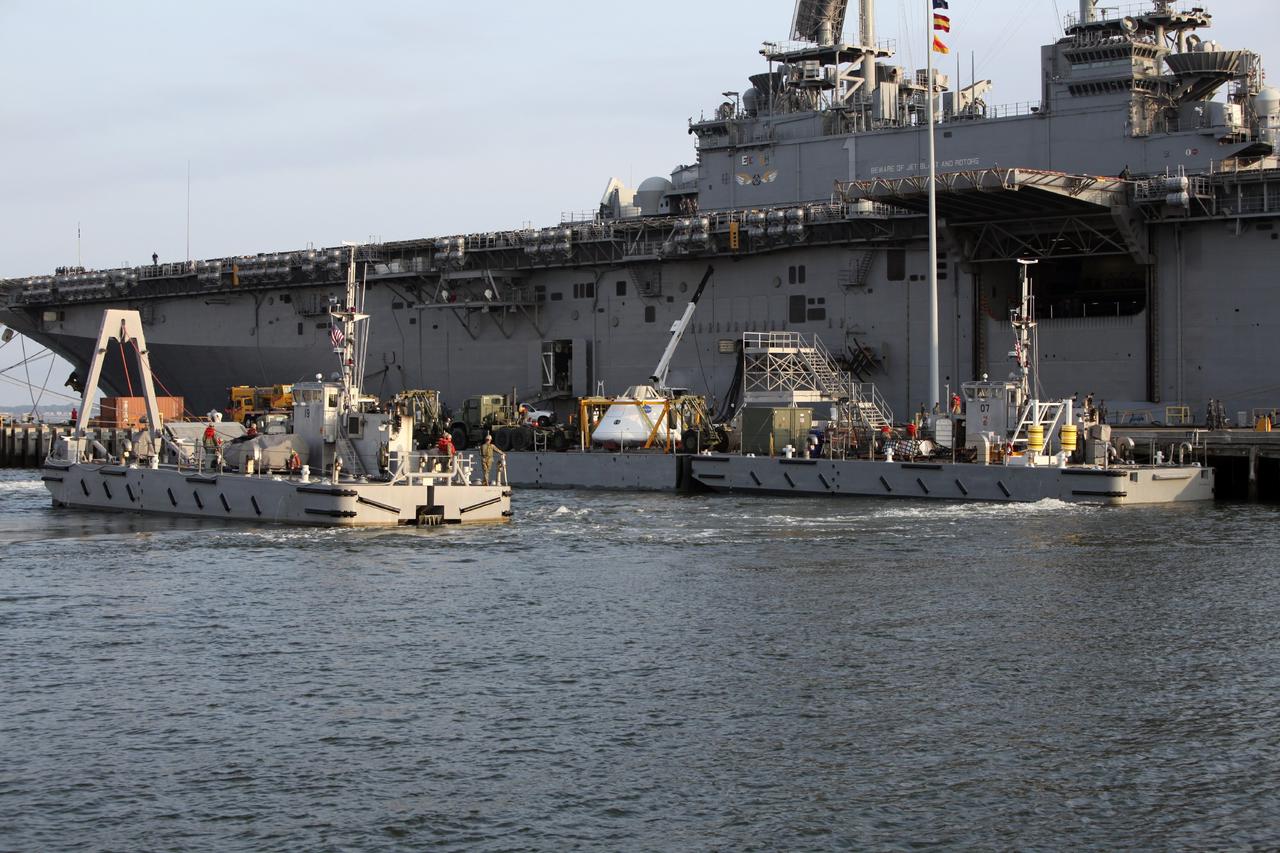 HAMPTON, Va. – At the Naval Station Norfolk near NASA’s Langley Research Center in Virginia, the Orion boilerplate test article and support equipment for a stationary recovery test are transferred by floating dock system to a U.S. Navy ship. NASA and the U.S. Navy are conducting tests to prepare for recovery of the Orion crew module and forward bay cover on its return from a deep space mission. The stationary recovery test will allow the teams to demonstrate and evaluate the recovery processes, procedures, hardware and personnel in a controlled environment before conducting a second recovery test next year in open waters. Orion is the exploration spacecraft designed to carry astronauts to destinations not yet explored by humans, including an asteroid and Mars. It will have emergency abort capability, sustain the crew during space travel and provide safe re-entry from deep space return velocities. The first unpiloted test flight of the Orion is scheduled to launch in 2014 atop a Delta IV rocket and in 2017 on a Space Launch System rocket. For more information, visit http://www.nasa.gov/orion. Photo credit: NASA/Dimitri Gerondidakis