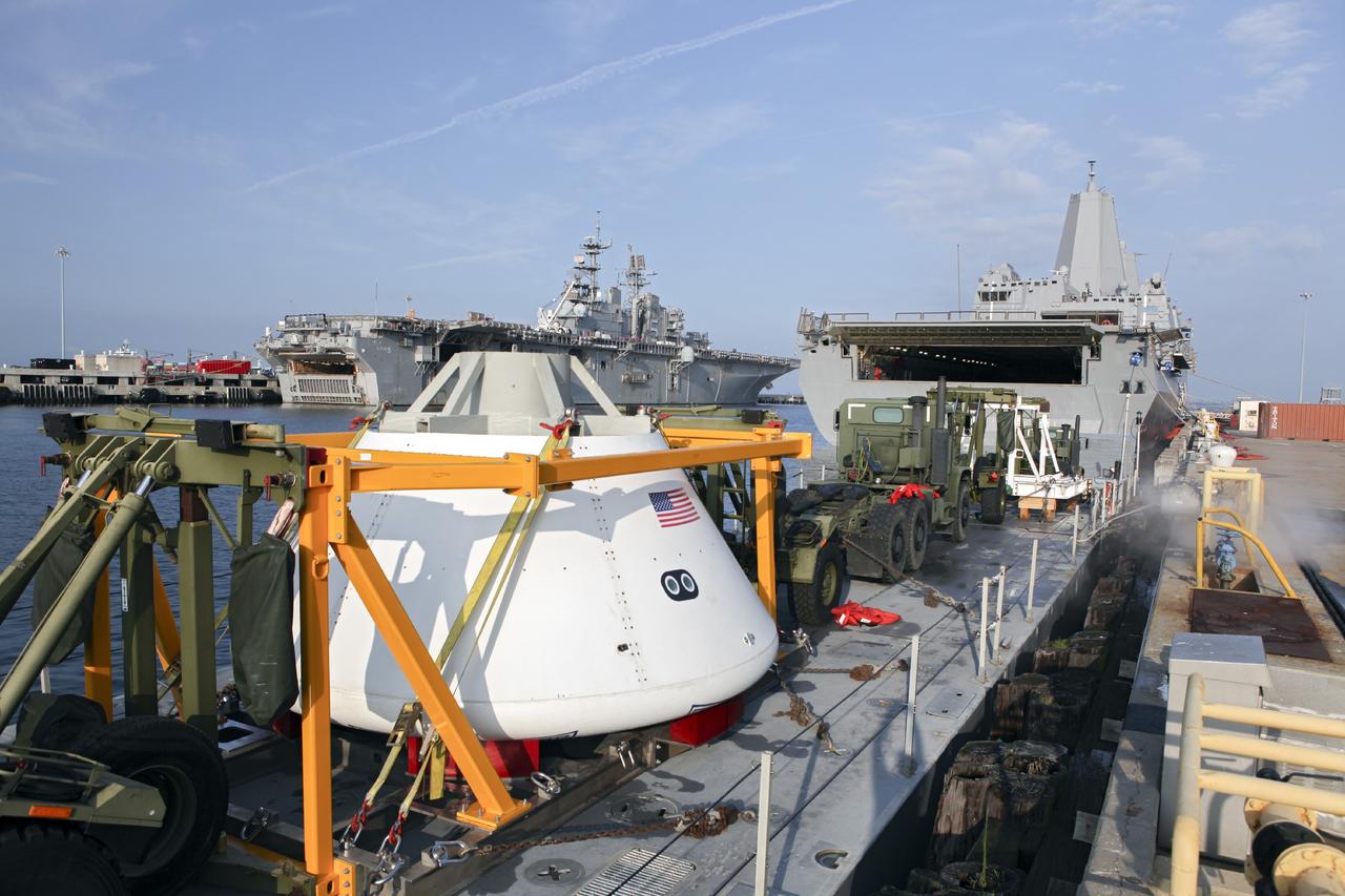 HAMPTON, Va. – At the Naval Station Norfolk near NASA’s Langley Research Center in Virginia, the Orion boilerplate test article and support equipment for a stationary recovery test are secured on a floating dock system for transfer to a U.S. Navy ship. NASA and the U.S. Navy are conducting tests to prepare for recovery of the Orion crew module and forward bay cover on its return from a deep space mission. The stationary recovery test will allow the teams to demonstrate and evaluate the recovery processes, procedures, hardware and personnel in a controlled environment before conducting a second recovery test next year in open waters. Orion is the exploration spacecraft designed to carry astronauts to destinations not yet explored by humans, including an asteroid and Mars. It will have emergency abort capability, sustain the crew during space travel and provide safe re-entry from deep space return velocities. The first unpiloted test flight of the Orion is scheduled to launch in 2014 atop a Delta IV rocket and in 2017 on a Space Launch System rocket. For more information, visit http://www.nasa.gov/orion. Photo credit: NASA/Dimitri Gerondidakis