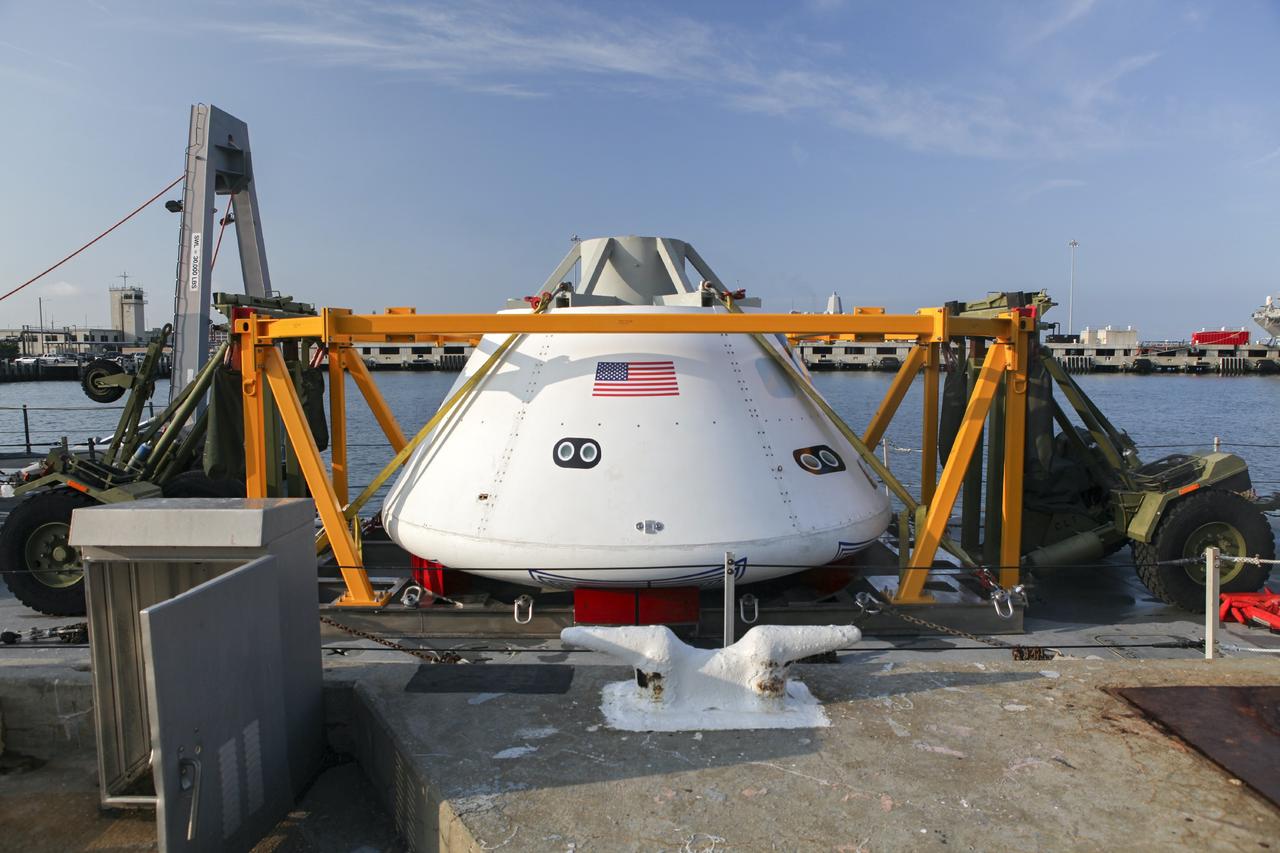 HAMPTON, Va. – At the Naval Station Norfolk near NASA’s Langley Research Center in Virginia, the Orion boilerplate test article and support equipment for a stationary recovery test are being transferred on a floating dock system to a U.S. Navy ship. NASA and the U.S. Navy are conducting tests to prepare for recovery of the Orion crew module and forward bay cover on its return from a deep space mission. The stationary recovery test will allow the teams to demonstrate and evaluate the recovery processes, procedures, hardware and personnel in a controlled environment before conducting a second recovery test next year in open waters. Orion is the exploration spacecraft designed to carry astronauts to destinations not yet explored by humans, including an asteroid and Mars. It will have emergency abort capability, sustain the crew during space travel and provide safe re-entry from deep space return velocities. The first unpiloted test flight of the Orion is scheduled to launch in 2014 atop a Delta IV rocket and in 2017 on a Space Launch System rocket. For more information, visit http://www.nasa.gov/orion. Photo credit: NASA/Dimitri Gerondidakis