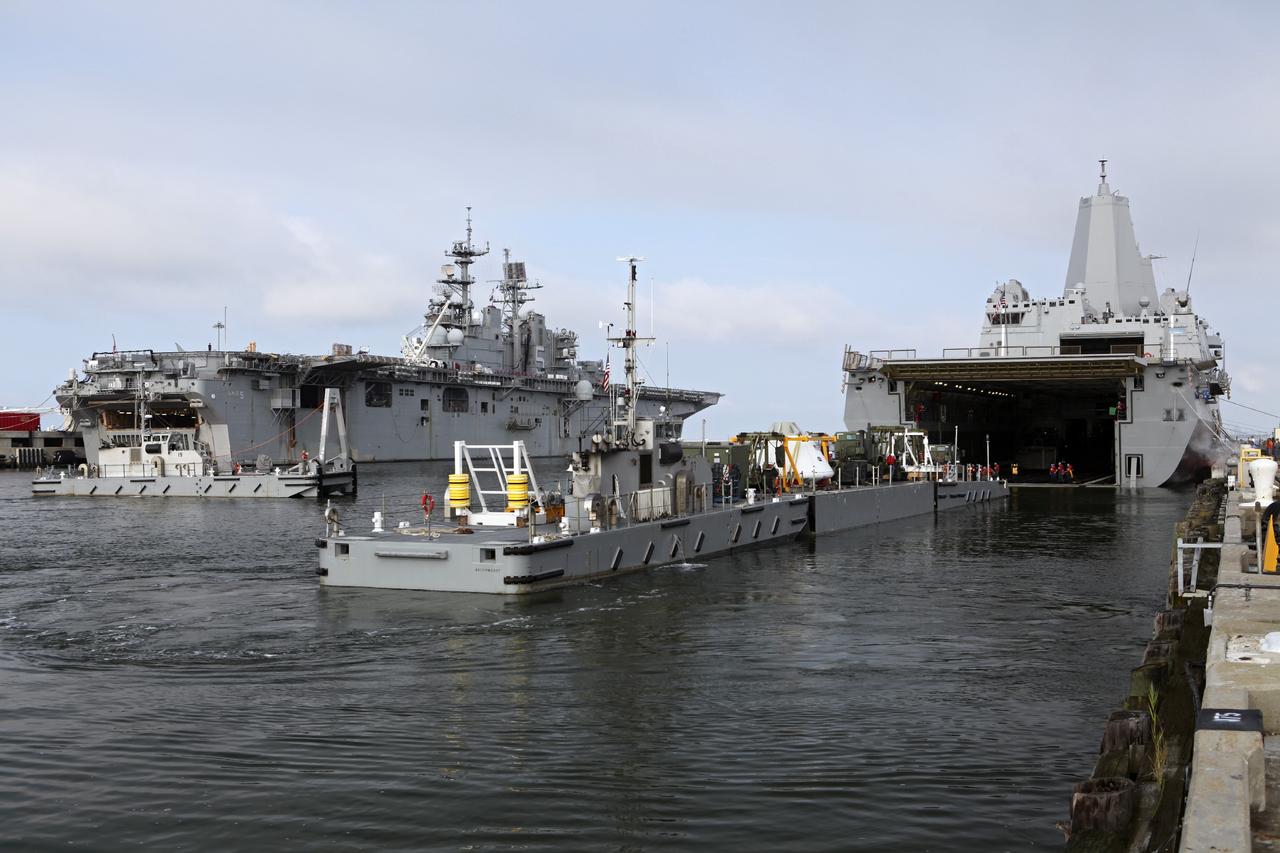 HAMPTON, Va. – At the Naval Station Norfolk near NASA’s Langley Research Center in Virginia, the Orion boilerplate test article and support equipment for a stationary recovery test are being transferred on a floating dock system to a U.S. Navy ship. NASA and the U.S. Navy are conducting tests to prepare for recovery of the Orion crew module and forward bay cover on its return from a deep space mission. The stationary recovery test will allow the teams to demonstrate and evaluate the recovery processes, procedures, hardware and personnel in a controlled environment before conducting a second recovery test next year in open waters. Orion is the exploration spacecraft designed to carry astronauts to destinations not yet explored by humans, including an asteroid and Mars. It will have emergency abort capability, sustain the crew during space travel and provide safe re-entry from deep space return velocities. The first unpiloted test flight of the Orion is scheduled to launch in 2014 atop a Delta IV rocket and in 2017 on a Space Launch System rocket. For more information, visit http://www.nasa.gov/orion. Photo credit: NASA/Dimitri Gerondidakis