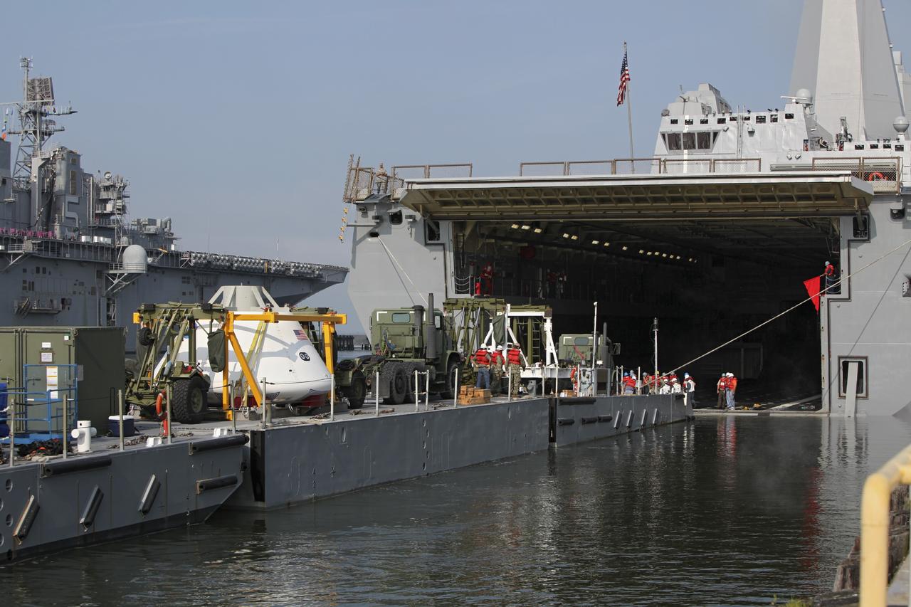 HAMPTON, Va. – At the Naval Station Norfolk near NASA’s Langley Research Center in Virginia, the Orion boilerplate test article and support equipment for a stationary recovery test are being transferred from a floating dock system to a U.S. Navy ship. NASA and the U.S. Navy are conducting tests to prepare for recovery of the Orion crew module and forward bay cover on its return from a deep space mission. The stationary recovery test will allow the teams to demonstrate and evaluate the recovery processes, procedures, hardware and personnel in a controlled environment before conducting a second recovery test next year in open waters. Orion is the exploration spacecraft designed to carry astronauts to destinations not yet explored by humans, including an asteroid and Mars. It will have emergency abort capability, sustain the crew during space travel and provide safe re-entry from deep space return velocities. The first unpiloted test flight of the Orion is scheduled to launch in 2014 atop a Delta IV rocket and in 2017 on a Space Launch System rocket. For more information, visit http://www.nasa.gov/orion. Photo credit: NASA/Dimitri Gerondidakis