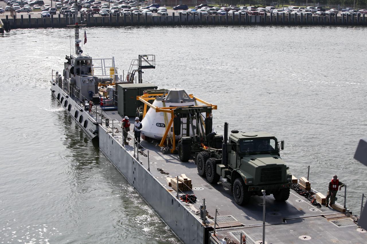 HAMPTON, Va. – At the Naval Station Norfolk near NASA’s Langley Research Center in Virginia, a floating dock system carries the Orion boilerplate test article and support equipment for a stationary recovery test aboard a U.S. Navy ship. NASA and the U.S. Navy are conducting tests to prepare for recovery of the Orion crew module and forward bay cover on its return from a deep space mission. The stationary recovery test will allow the teams to demonstrate and evaluate the recovery processes, procedures, hardware and personnel in a controlled environment before conducting a second recovery test next year in open waters. Orion is the exploration spacecraft designed to carry astronauts to destinations not yet explored by humans, including an asteroid and Mars. It will have emergency abort capability, sustain the crew during space travel and provide safe re-entry from deep space return velocities. The first unpiloted test flight of the Orion is scheduled to launch in 2014 atop a Delta IV rocket and in 2017 on NASA’s Space Launch System rocket. For more information, visit http://www.nasa.gov/orion. Photo credit: NASA/Dimitri Gerondidakis