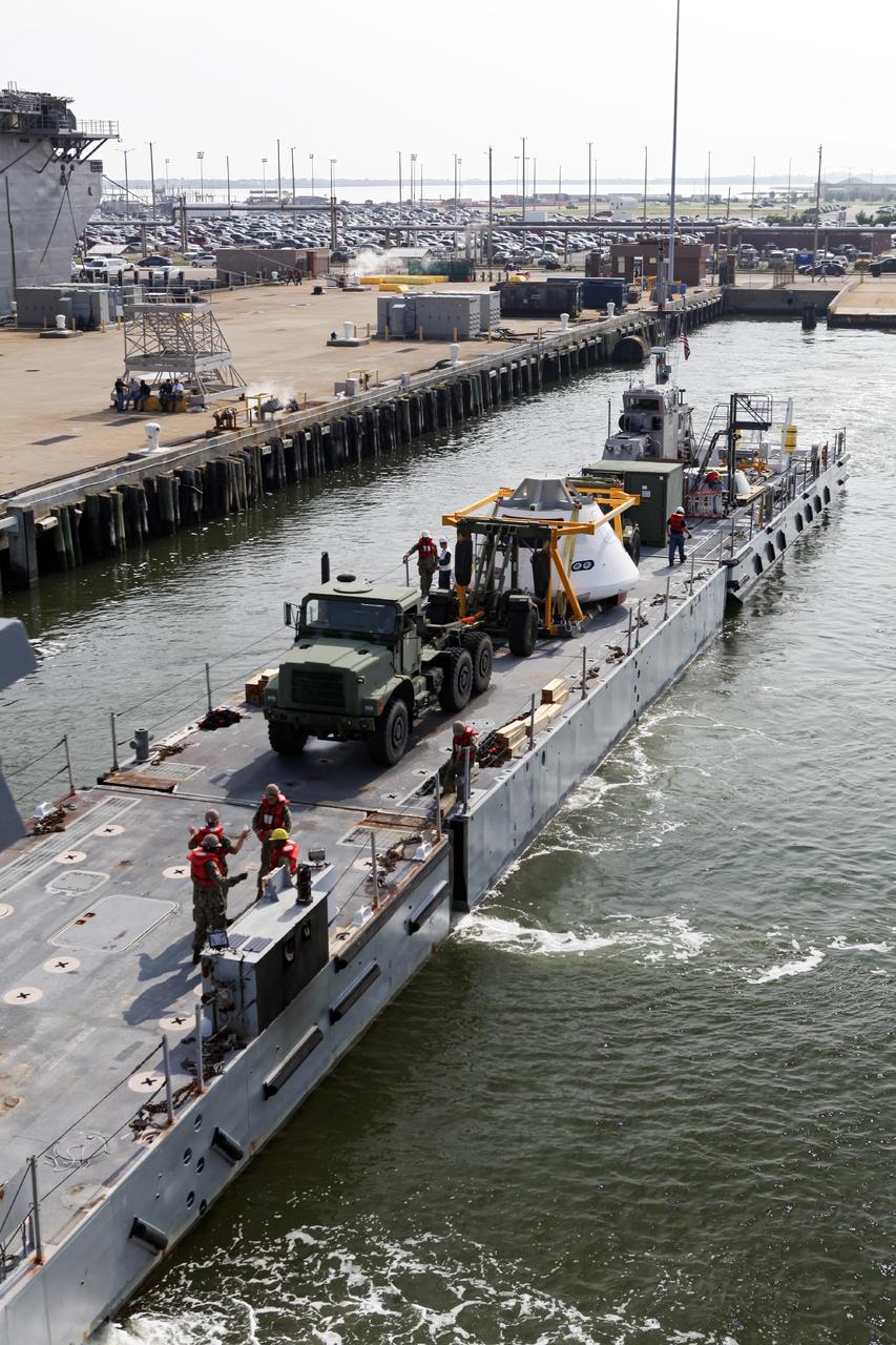 HAMPTON, Va. – At the Naval Station Norfolk near NASA’s Langley Research Center in Virginia, a floating dock system carries the Orion boilerplate test article and support equipment for a stationary recovery test aboard a U.S. Navy ship. NASA and the U.S. Navy are conducting tests to prepare for recovery of the Orion crew module and forward bay cover on its return from a deep space mission. The stationary recovery test will allow the teams to demonstrate and evaluate the recovery processes, procedures, hardware and personnel in a controlled environment before conducting a second recovery test next year in open waters. Orion is the exploration spacecraft designed to carry astronauts to destinations not yet explored by humans, including an asteroid and Mars. It will have emergency abort capability, sustain the crew during space travel and provide safe re-entry from deep space return velocities. The first unpiloted test flight of the Orion is scheduled to launch in 2014 atop a Delta IV rocket and in 2017 on NASA’s Space Launch System rocket. For more information, visit http://www.nasa.gov/orion. Photo credit: NASA/Dimitri Gerondidakis