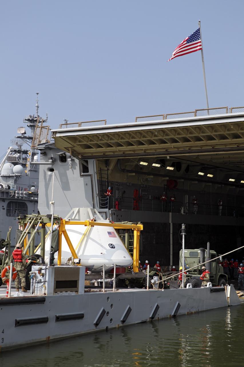 HAMPTON, Va. – At the Naval Station Norfolk near NASA’s Langley Research Center in Virginia, the Orion boilerplate test article and support equipment for a stationary recovery test are transferred by floating dock system to a U.S. Navy ship. NASA and the U.S. Navy are conducting tests to prepare for recovery of the Orion crew module and forward bay cover on its return from a deep space mission. The stationary recovery test will allow the teams to demonstrate and evaluate the recovery processes, procedures, hardware and personnel in a controlled environment before conducting a second recovery test next year in open waters. Orion is the exploration spacecraft designed to carry astronauts to destinations not yet explored by humans, including an asteroid and Mars. It will have emergency abort capability, sustain the crew during space travel and provide safe re-entry from deep space return velocities. The first unpiloted test flight of the Orion is scheduled to launch in 2014 atop a Delta IV rocket and in 2017 on NASA’s Space Launch System rocket. For more information, visit http://www.nasa.gov/orion. Photo credit: NASA/Dimitri Gerondidakis