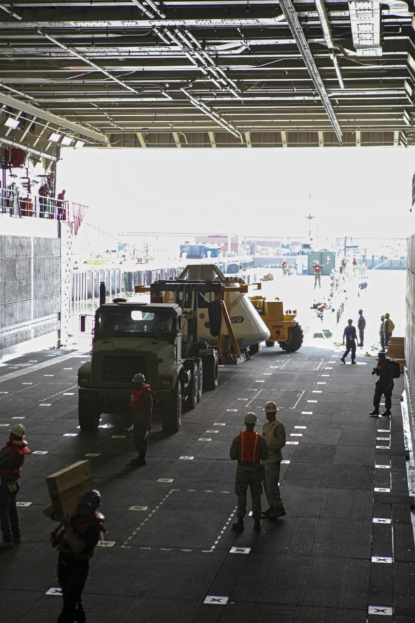 HAMPTON, Va. – At the Naval Station Norfolk near NASA’s Langley Research Center in Virginia, the Orion boilerplate test article and support equipment for a stationary recovery test are transferred to a U.S. Navy ship from a floating dock system. NASA and the U.S. Navy are conducting tests to prepare for recovery of the Orion crew module and forward bay cover on its return from a deep space mission. The stationary recovery test will allow the teams to demonstrate and evaluate the recovery processes, procedures, hardware and personnel in a controlled environment before conducting a second recovery test next year in open waters. Orion is the exploration spacecraft designed to carry astronauts to destinations not yet explored by humans, including an asteroid and Mars. It will have emergency abort capability, sustain the crew during space travel and provide safe re-entry from deep space return velocities. The first unpiloted test flight of the Orion is scheduled to launch in 2014 atop a Delta IV rocket and in 2017 on NASA’s Space Launch System rocket. For more information, visit http://www.nasa.gov/orion. Photo credit: NASA/Dimitri Gerondidakis