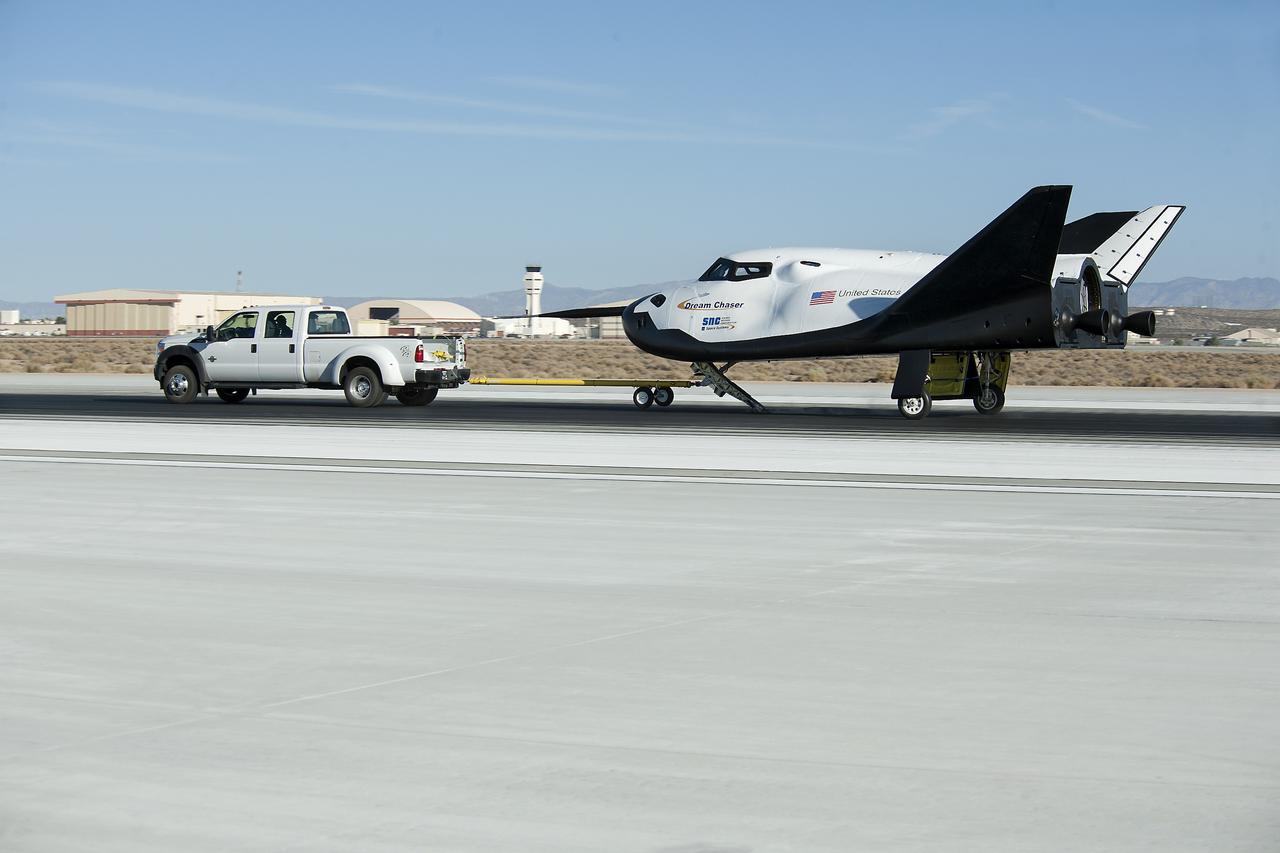 Edwards, Calif. – ED13-0266-049- A pickup truck pulls the Sierra Nevada Corporation, or SNC, Dream Chaser flight vehicle through 60 mile per hour tow tests on taxi and runways at NASA's Dryden Flight Research Center at Edwards Air Force Base in California. Ground testing at 10, 20, 40 and 60 miles per hour is helping the company validate the performance of the spacecraft's braking and landing systems prior to captive-carry and free-flight tests scheduled for later this year.              SNC is continuing the development of its Dream Chaser spacecraft under the agency's Commercial Crew Development Round 2, or CCDev2, and Commercial Crew Integrated Capability, or CCiCap, phases, which are intended to lead to the availability of commercial human spaceflight services for government and commercial customers. To learn more about CCP and its industry partners, visit www.nasa.gov/commercialcrew. Image credit: NASA/Ken Ulbrich