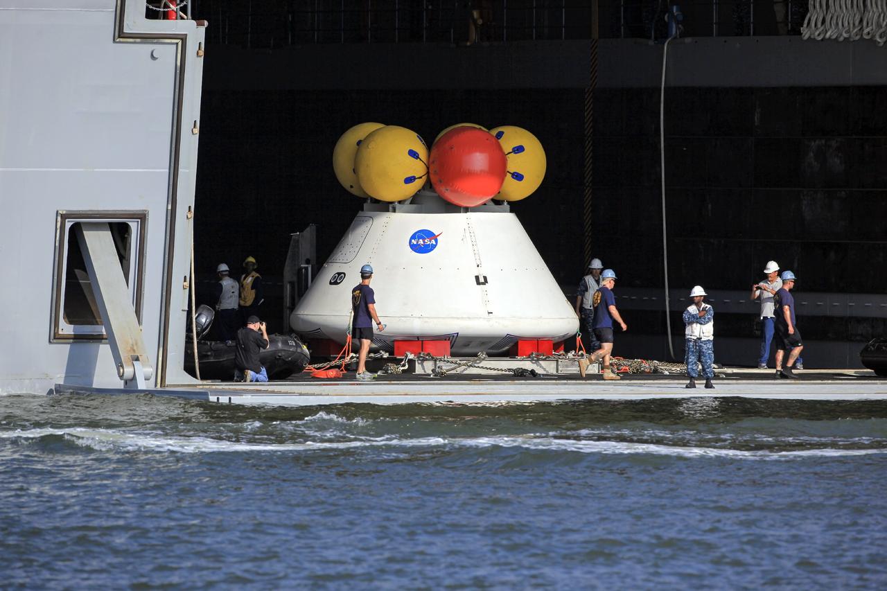 HAMPTON, Va. – At the Naval Station Norfolk near NASA’s Langley Research Center in Virginia, NASA and U.S. Navy personnel prepare the Orion boilerplate test article for a stationary recovery test aboard a U.S. Navy ship. NASA and the U.S. Navy are conducting tests to prepare for recovery of the Orion crew module and forward bay cover on its return from a deep space mission. The stationary recovery test will allow the teams to demonstrate and evaluate the recovery processes, procedures, hardware and personnel in a controlled environment before conducting a second recovery test next year in open waters. Orion is the exploration spacecraft designed to carry astronauts to destinations not yet explored by humans, including an asteroid and Mars. It will have emergency abort capability, sustain the crew during space travel and provide safe re-entry from deep space return velocities. The first unpiloted test flight of the Orion is scheduled to launch in 2014 atop a Delta IV rocket and in 2017 on NASA’s Space Launch System rocket. For more information, visit http://www.nasa.gov/orion. Photo credit: NASA/Dimitri Gerondidakis