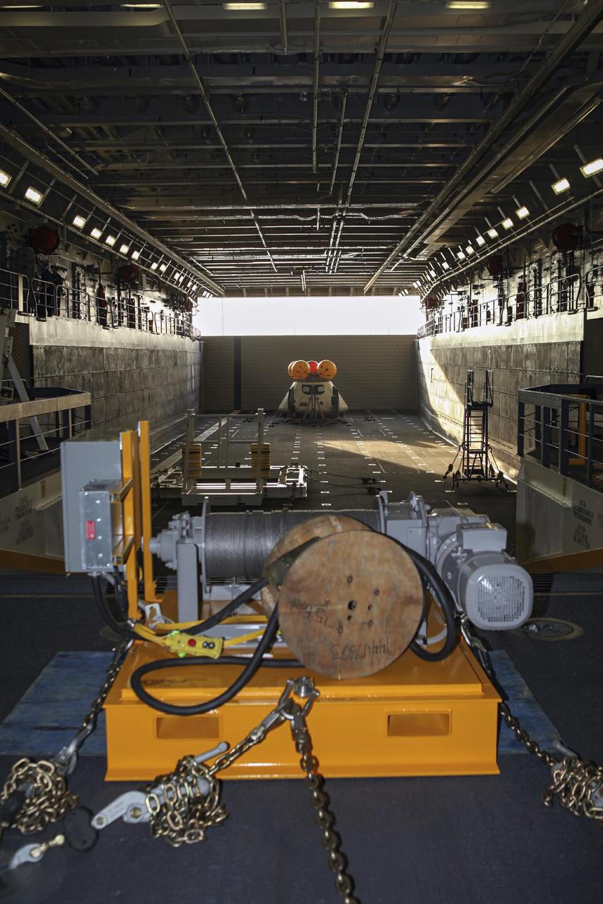 HAMPTON, Va. – At the Naval Station Norfolk near NASA’s Langley Research Center in Virginia, the Orion boilerplate test article and support equipment for a stationary recovery test are secured on a U.S. Navy ship. NASA and the U.S. Navy are conducting tests to prepare for recovery of the Orion crew module and forward bay cover on its return from a deep space mission. The stationary recovery test will allow the teams to demonstrate and evaluate the recovery processes, procedures, hardware and personnel in a controlled environment before conducting a second recovery test next year in open waters. Orion is the exploration spacecraft designed to carry astronauts to destinations not yet explored by humans, including an asteroid and Mars. It will have emergency abort capability, sustain the crew during space travel and provide safe re-entry from deep space return velocities. The first unpiloted test flight of the Orion is scheduled to launch in 2014 atop a Delta IV rocket and in 2017 on NASA’s Space Launch System rocket. For more information, visit http://www.nasa.gov/orion. Photo credit: NASA/Dimitri Gerondidakis