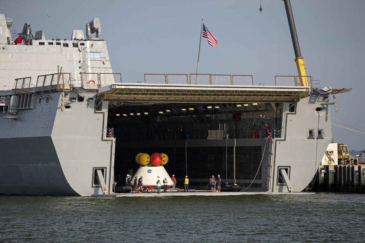 HAMPTON, Va. – At the Naval Station Norfolk near NASA’s Langley Research Center in Virginia, NASA and U.S. Navy personnel prepare the Orion boilerplate test article and support equipment for a stationary recovery test on a U.S. Navy ship. NASA and the U.S. Navy are conducting tests to prepare for recovery of the Orion crew module and forward bay cover on its return from a deep space mission. The stationary recovery test will allow the teams to demonstrate and evaluate the recovery processes, procedures, hardware and personnel in a controlled environment before conducting a second recovery test next year in open waters. Orion is the exploration spacecraft designed to carry astronauts to destinations not yet explored by humans, including an asteroid and Mars. It will have emergency abort capability, sustain the crew during space travel and provide safe re-entry from deep space return velocities. The first unpiloted test flight of the Orion is scheduled to launch in 2014 atop a Delta IV rocket and in 2017 on NASA’s Space Launch System rocket. For more information, visit http://www.nasa.gov/orion. Photo credit: NASA/Dimitri Gerondidakis