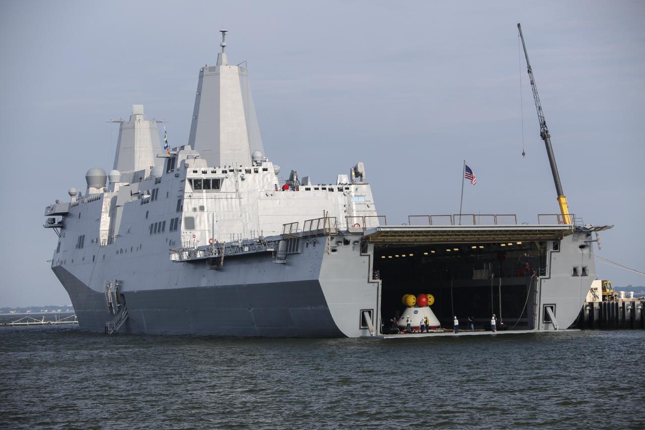HAMPTON, Va. – At the Naval Station Norfolk near NASA’s Langley Research Center in Virginia, NASA and U.S. Navy personnel prepare the Orion boilerplate test article and support equipment for a stationary recovery test on a U.S. Navy ship. NASA and the U.S. Navy are conducting tests to prepare for recovery of the Orion crew module and forward bay cover on its return from a deep space mission. The stationary recovery test will allow the teams to demonstrate and evaluate the recovery processes, procedures, hardware and personnel in a controlled environment before conducting a second recovery test next year in open waters. Orion is the exploration spacecraft designed to carry astronauts to destinations not yet explored by humans, including an asteroid and Mars. It will have emergency abort capability, sustain the crew during space travel and provide safe re-entry from deep space return velocities. The first unpiloted test flight of the Orion is scheduled to launch in 2014 atop a Delta IV rocket and in 2017 on NASA’s Space Launch System rocket. For more information, visit http://www.nasa.gov/orion. Photo credit: NASA/Dimitri Gerondidakis