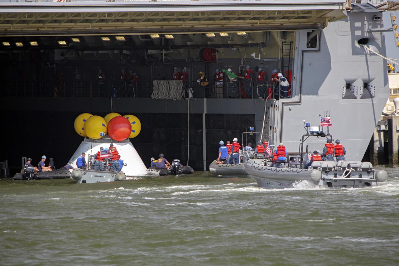 HAMPTON, Va. – At the Naval Station Norfolk near NASA’s Langley Research Center in Virginia, the Orion boilerplate test article is being moved from a U.S. Navy ship and placed in the water for a stationary recovery test. NASA and the U.S. Navy are conducting tests to prepare for recovery of the Orion crew module and forward bay cover on its return from a deep space mission. The stationary recovery test will allow the teams to demonstrate and evaluate the recovery processes, procedures, hardware and personnel in a controlled environment before conducting a second recovery test next year in open waters. Orion is the exploration spacecraft designed to carry astronauts to destinations not yet explored by humans, including an asteroid and Mars. It will have emergency abort capability, sustain the crew during space travel and provide safe re-entry from deep space return velocities. The first unpiloted test flight of the Orion is scheduled to launch in 2014 atop a Delta IV rocket and in 2017 on NASA’s Space Launch System rocket. For more information, visit http://www.nasa.gov/orion. Photo credit: NASA/Dimitri Gerondidakis