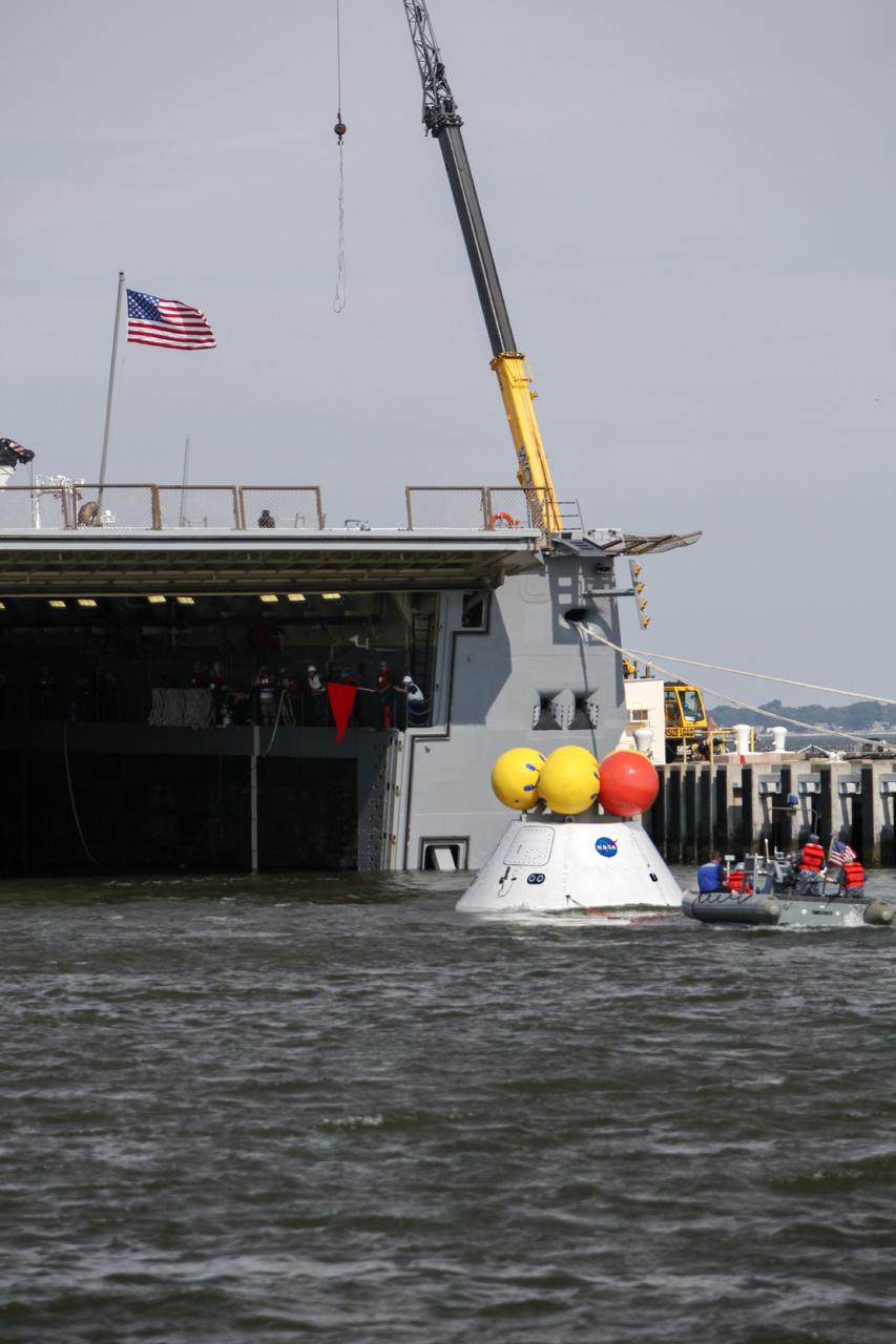 HAMPTON, Va. – At the Naval Station Norfolk near NASA’s Langley Research Center in Virginia, the Orion boilerplate test article has been moved from a U.S. Navy ship and placed in the water for a stationary recovery test. NASA and the U.S. Navy are conducting tests to prepare for recovery of the Orion crew module and forward bay cover on its return from a deep space mission. The stationary recovery test will allow the teams to demonstrate and evaluate the recovery processes, procedures, hardware and personnel in a controlled environment before conducting a second recovery test next year in open waters. Orion is the exploration spacecraft designed to carry astronauts to destinations not yet explored by humans, including an asteroid and Mars. It will have emergency abort capability, sustain the crew during space travel and provide safe re-entry from deep space return velocities. The first unpiloted test flight of the Orion is scheduled to launch in 2014 atop a Delta IV rocket and in 2017 on NASA’s Space Launch System rocket. For more information, visit http://www.nasa.gov/orion. Photo credit: NASA/Dimitri Gerondidakis