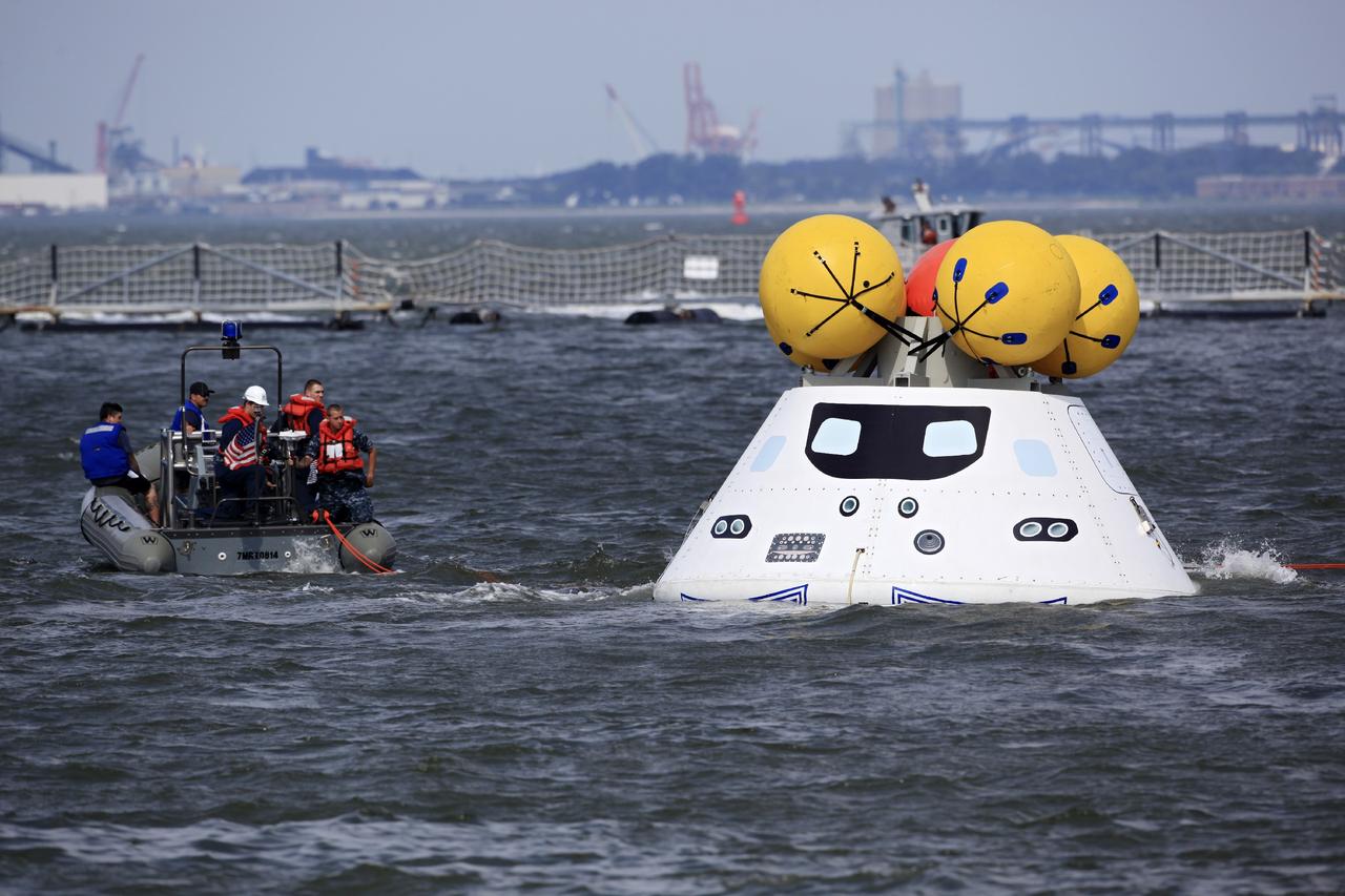 HAMPTON, Va. – At the Naval Station Norfolk near NASA’s Langley Research Center in Virginia, U.S. Navy personnel approach the Orion boilerplate test article during a stationary recovery test in the water. NASA and the U.S. Navy are conducting tests to prepare for recovery of the Orion crew module and forward bay cover on its return from a deep space mission. The stationary recovery test will allow the teams to demonstrate and evaluate the recovery processes, procedures, hardware and personnel in a controlled environment before conducting a second recovery test next year in open waters. Orion is the exploration spacecraft designed to carry astronauts to destinations not yet explored by humans, including an asteroid and Mars. It will have emergency abort capability, sustain the crew during space travel and provide safe re-entry from deep space return velocities. The first unpiloted test flight of the Orion is scheduled to launch in 2014 atop a Delta IV rocket and in 2017 on NASA’s Space Launch System rocket. For more information, visit http://www.nasa.gov/orion. Photo credit: NASA/Dimitri Gerondidakis